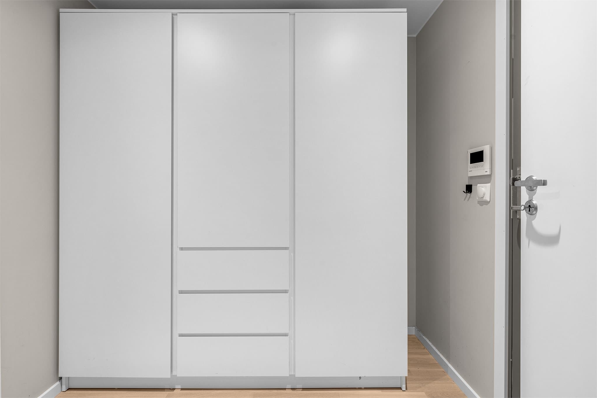 Leiligheten har en innbydende entré med plass til å henge fra seg yttertøy og sette fra seg sko. Det er også montert porttelefon med kamera.