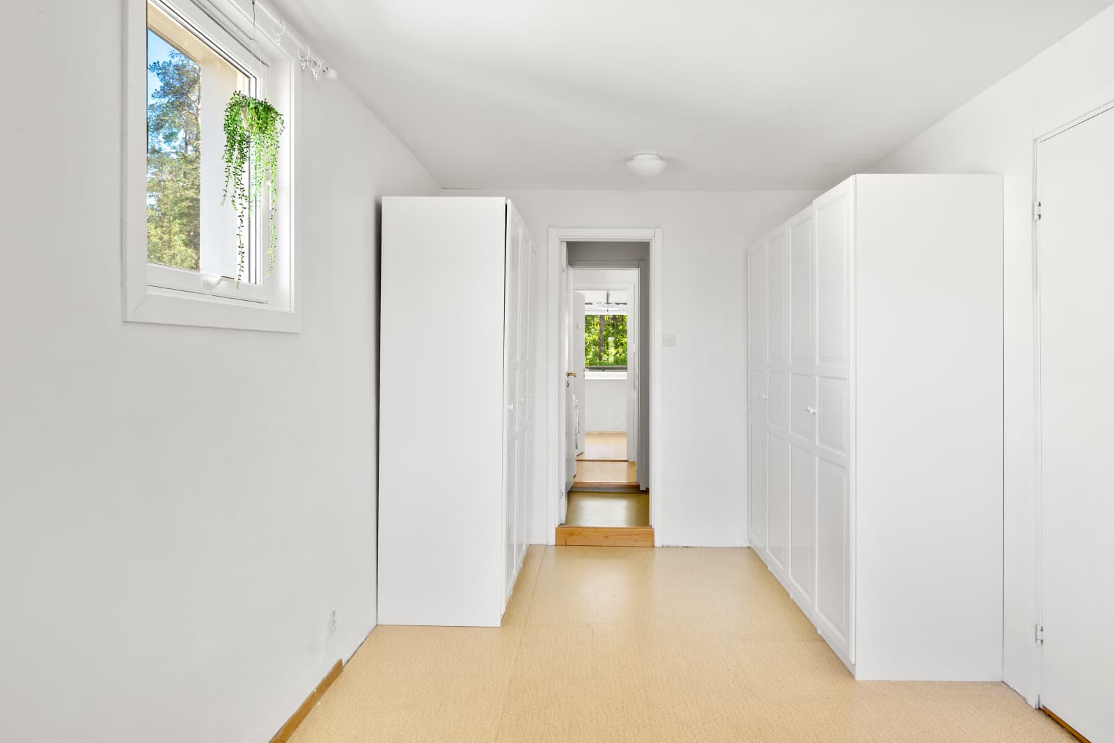 Walk in, walk out: Før du trer inn på badet, finner du doble garderobeskap som gir rikelig med oppbevaringsplass – en løsning som ofte brukes som en praktisk “walk-through”-garderobe, hvor klær og tilbehør holdes ryddig og lett tilgjengelig.