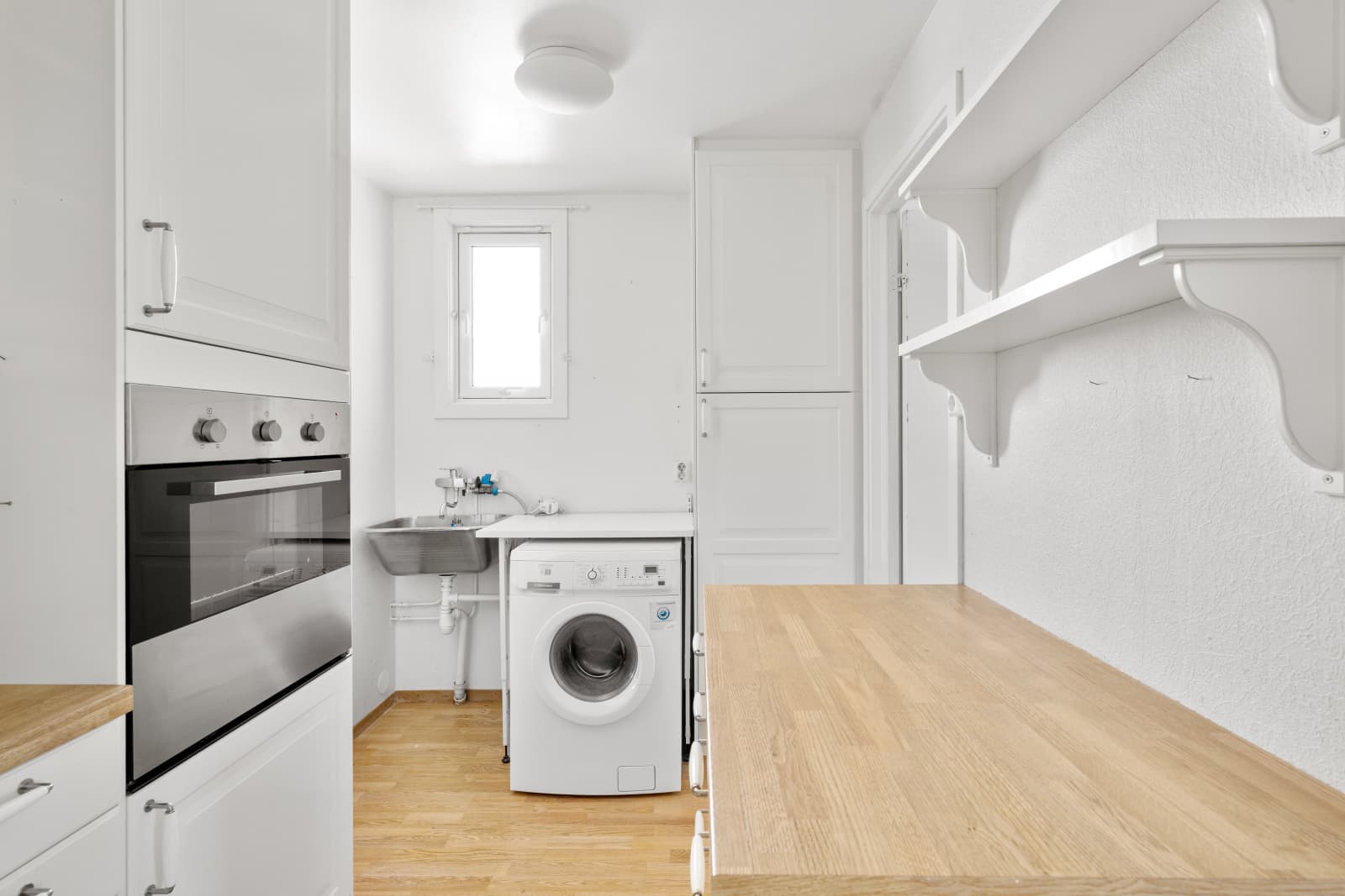 Innerst på kjøkkenet finner du et avdelt grovkjøkken. Her er det opplegg for vaskemaskin, utslagsvask og høyskap med god plass til langkost, mopp og rengjøringsutstyr.