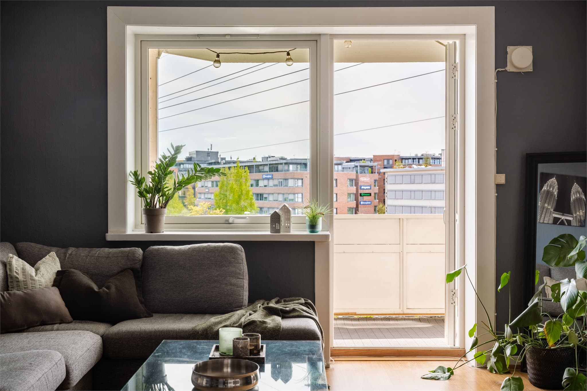 De store vindusflatene og balkongdøren gir godt med lys til stuen.