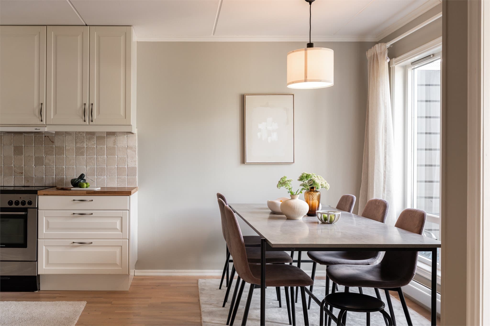 Leiligheten har et lyst og trivelig kjøkken med plass til stor spisegruppe ved vinduet - Et naturlig samlingspunkt for måltider og hyggelige stunder.