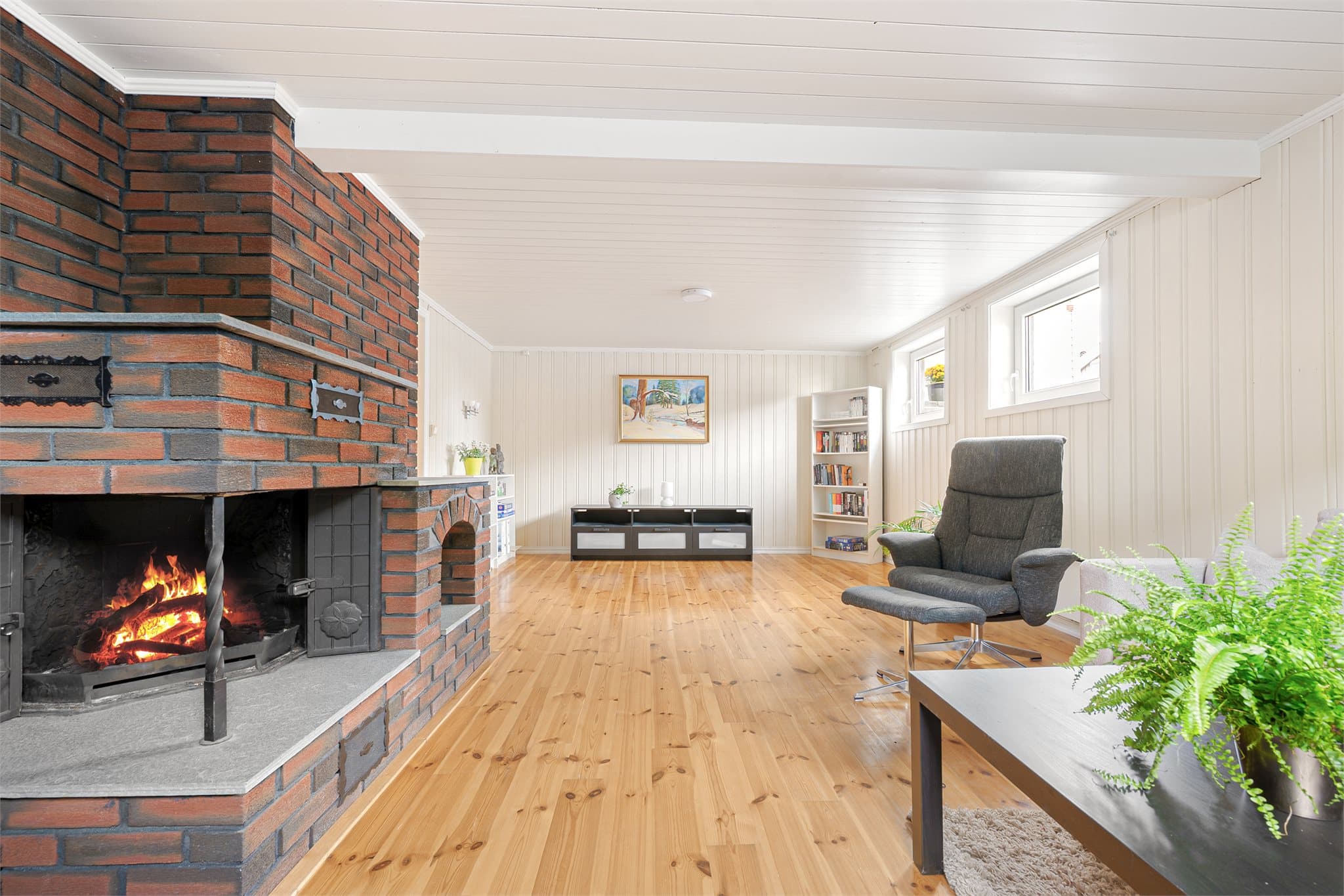 Teglsteinspeisen med peisinnsats gir rommet en varm og koselig atmosfære. Rommet er bruksendret til varig oppholdsrom og gir familien et ekstra oppholdsareal – perfekt som ungdoms-/TV-stue, hobbyrom eller for familien med behov for flere soverom.