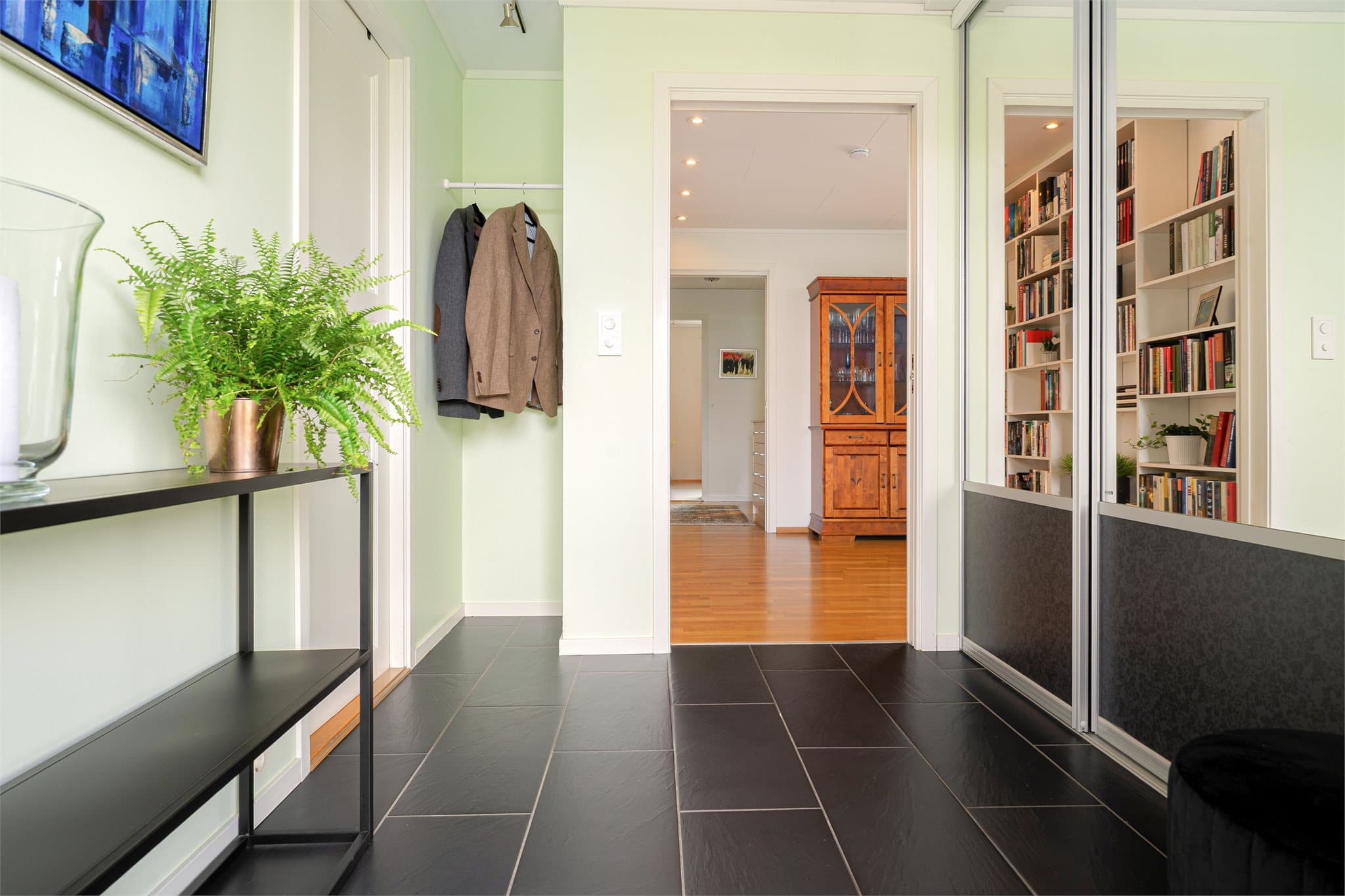 Velkommen inn! Innbydene entré med fliser på gulv og skyvedørsgarderobe med speilfronter.
