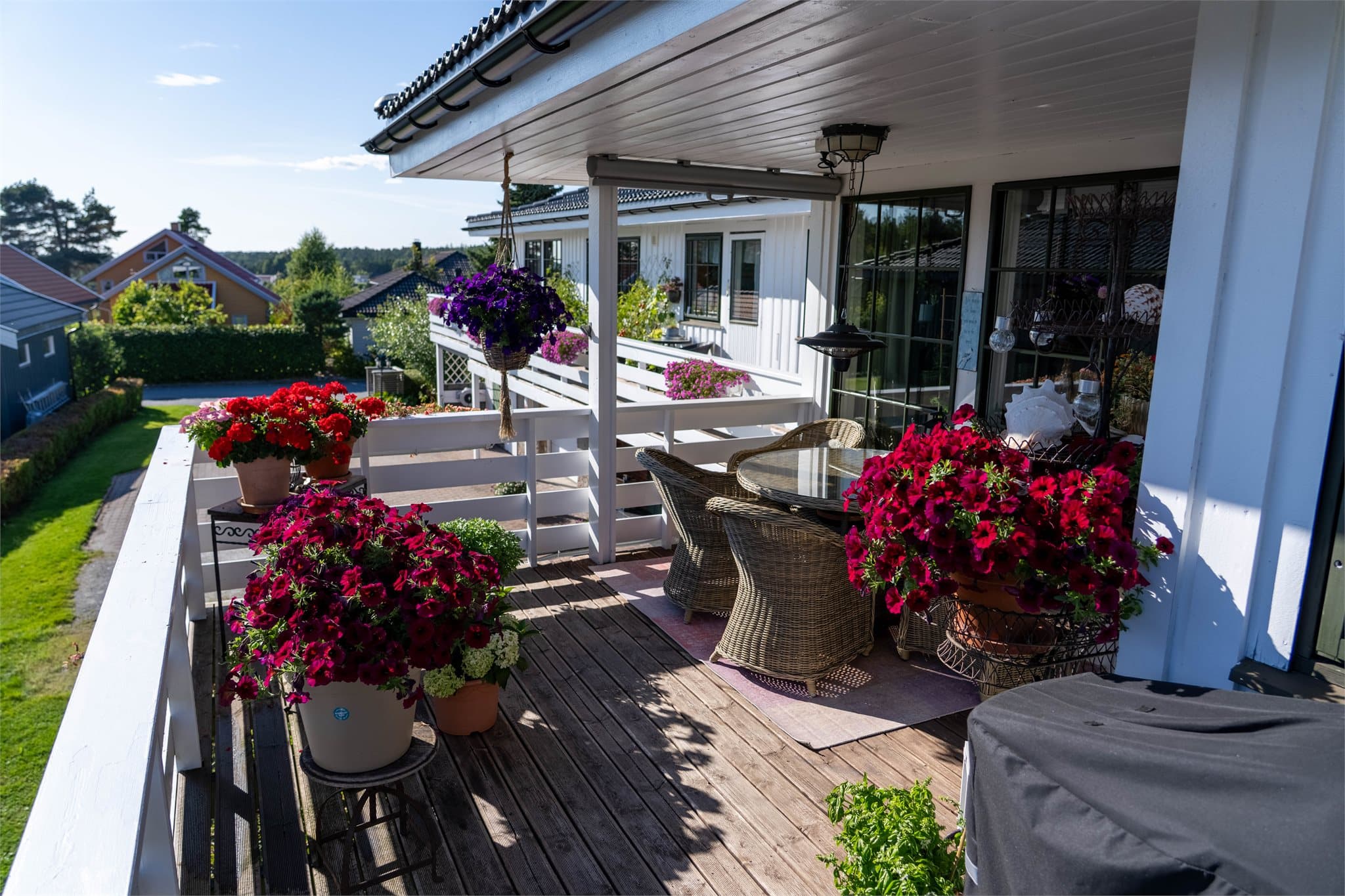 Terrasse i trekonstruksjon tilknyttet 1. etasje med rekkverk i tre.