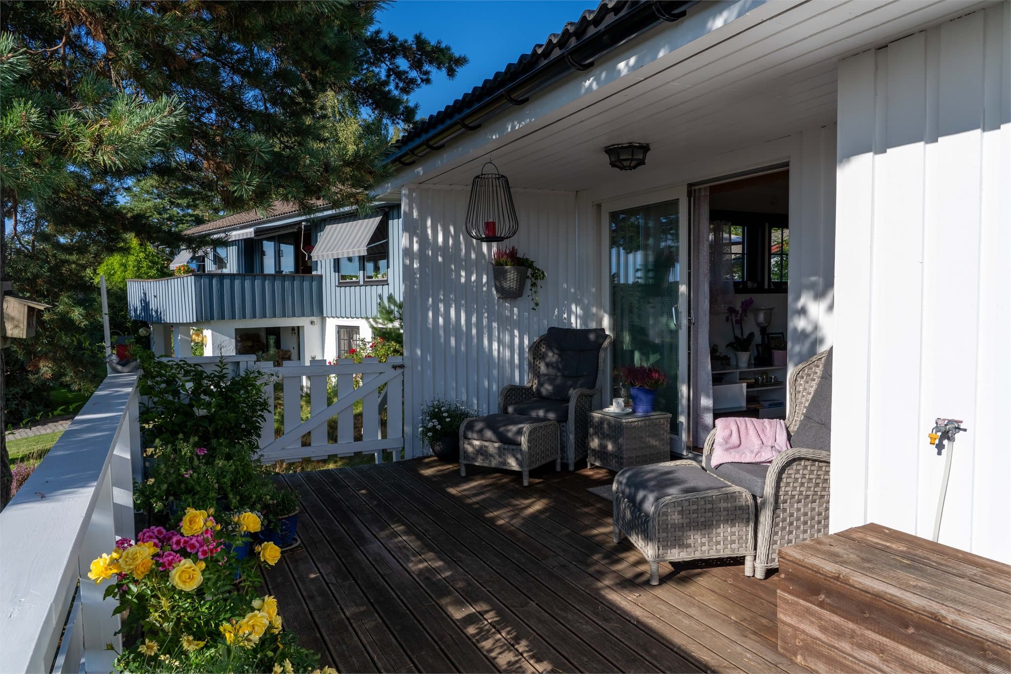 Terrasse i trevirke med direkte adkomst fra stuen via skyvedør.