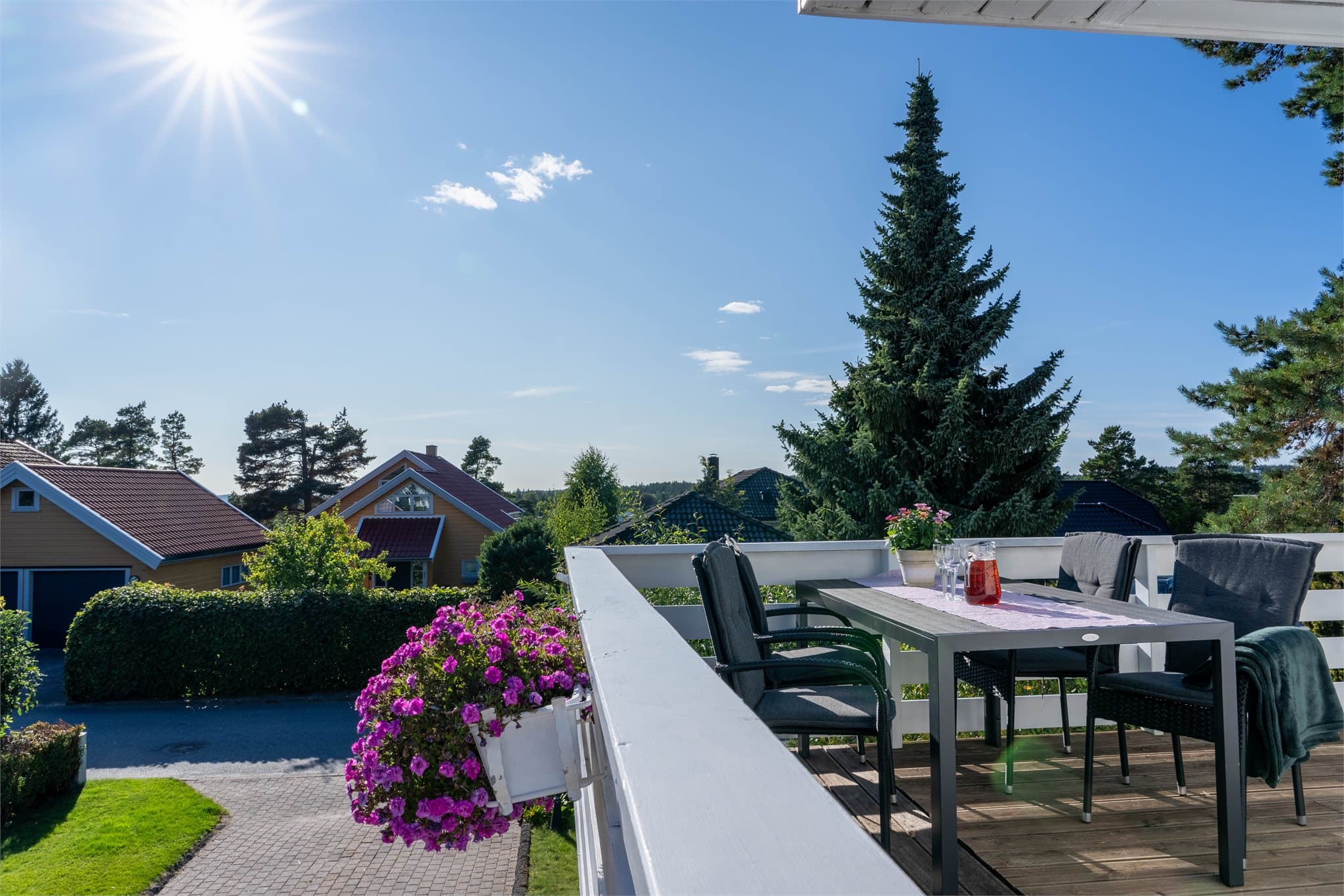 Terrasse mot sør med utkraget trekonstruksjon og rekkverk.