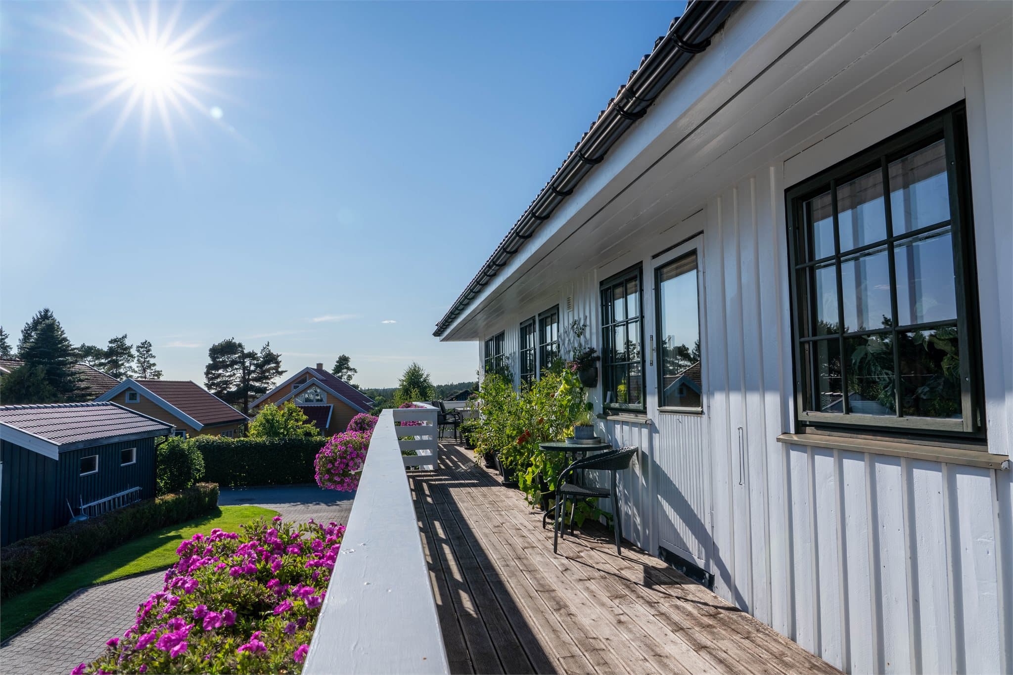 Langsgående terrasseareal med tredekke langs fasaden.