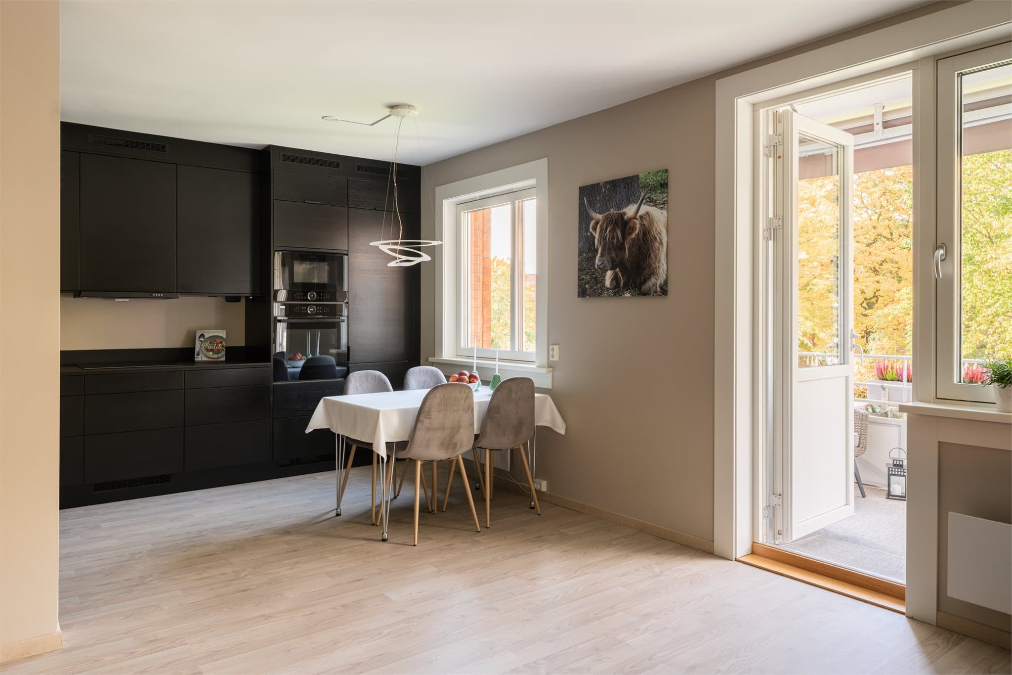 Leiligheten har en delvis åpen løsning mellom stue og kjøkken, med direkte utgang til balkongen.