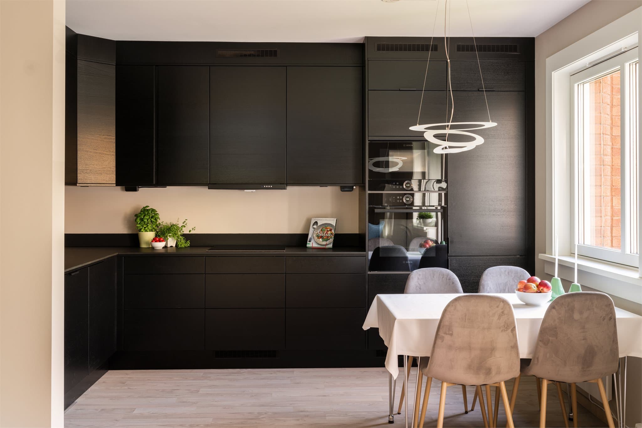 Kjøkkenet fra 2023 har en stilren innredning med glatte, mørke fronter og rikelig med skapplass.