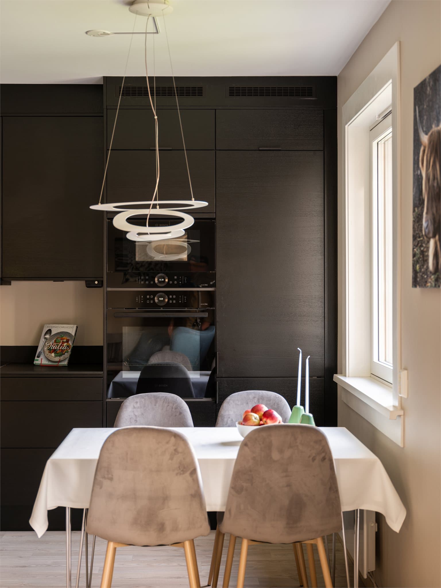 Høyskap med integrerte hvitevarer bidrar til et ryddig og helhetlig uttrykk.