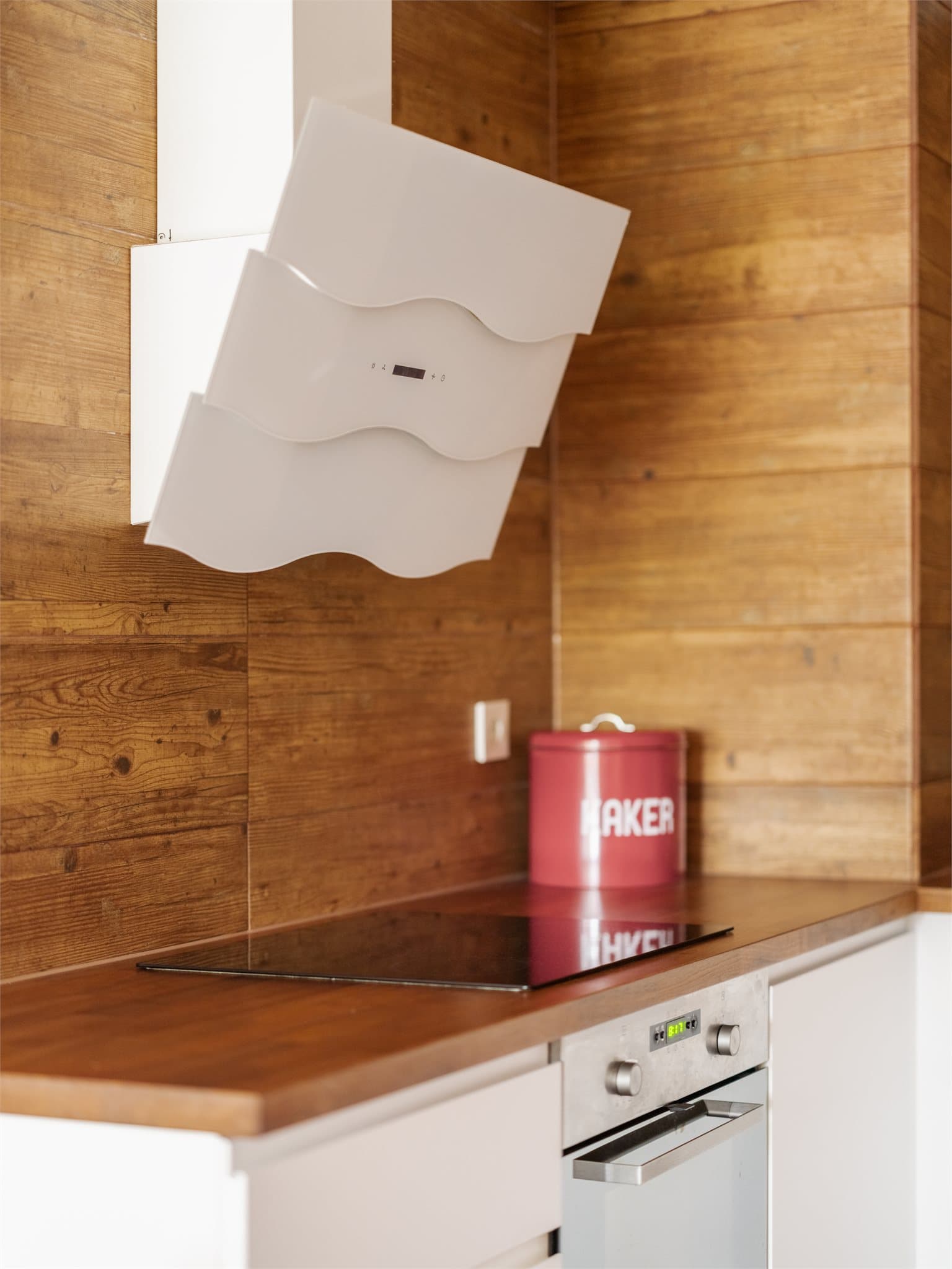 Kjøkkenventilator med kullfilter over induksjonstoppen.