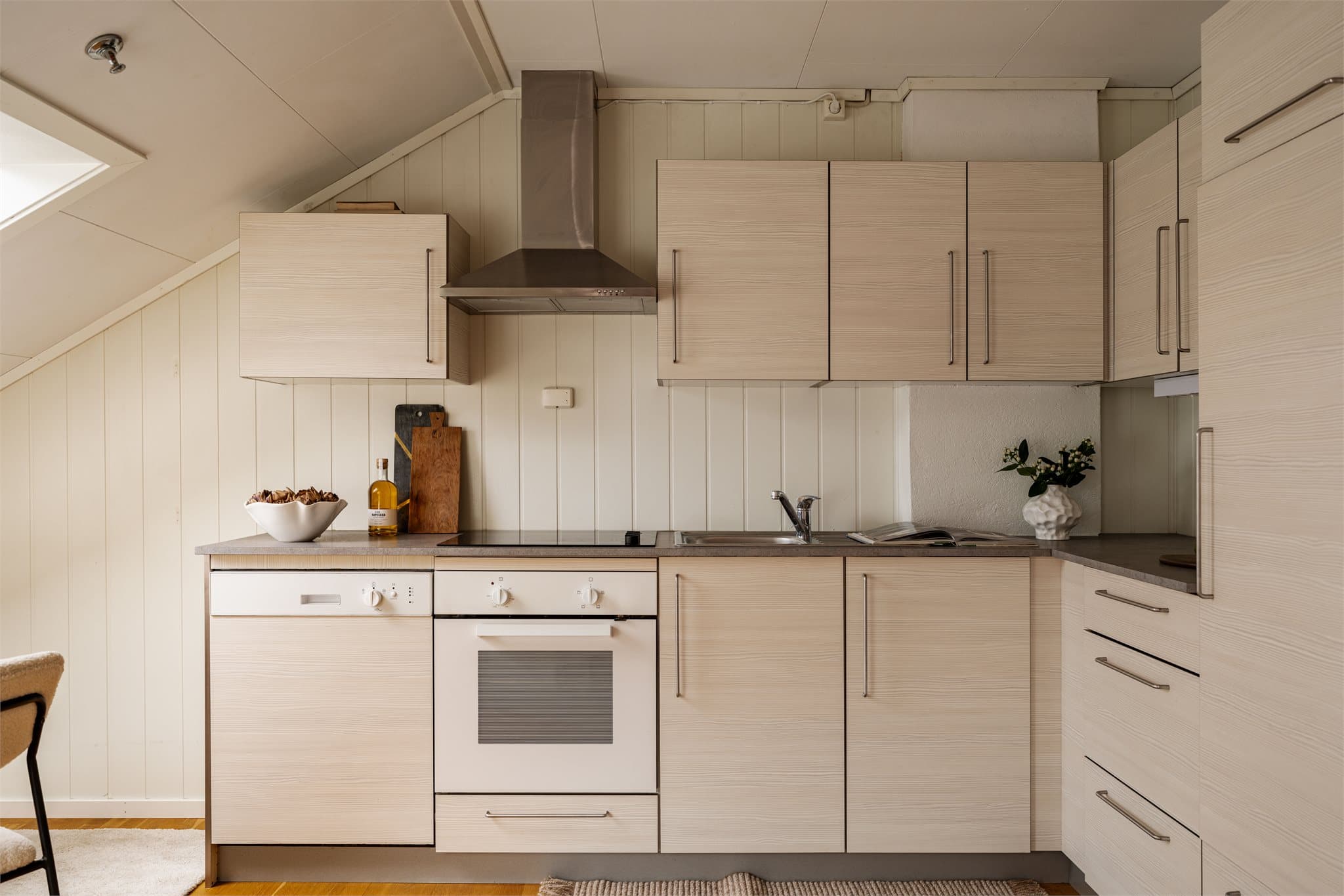 Kjøkkenet er utstyrt med komfyr, oppvaskmaskin og kjøleskap (2026), og ventilator med kullfilter er plassert over kokesonen. Det er også installert komfyrvakt for økt sikkerhet.