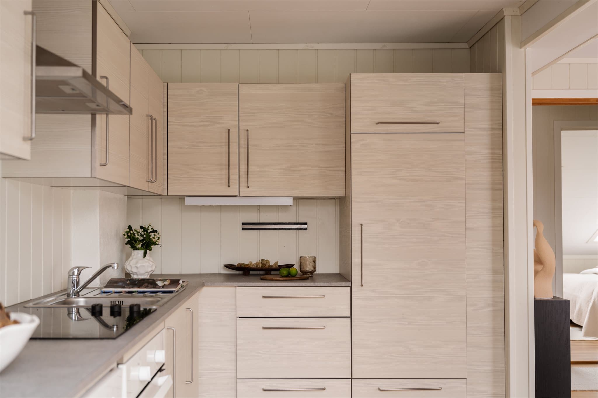 Kjøkkeninnredningen fra Ikea har et delikat og tidløst uttrykk med slette fronter og laminat benkeplate med nedfelt oppvaskkum.