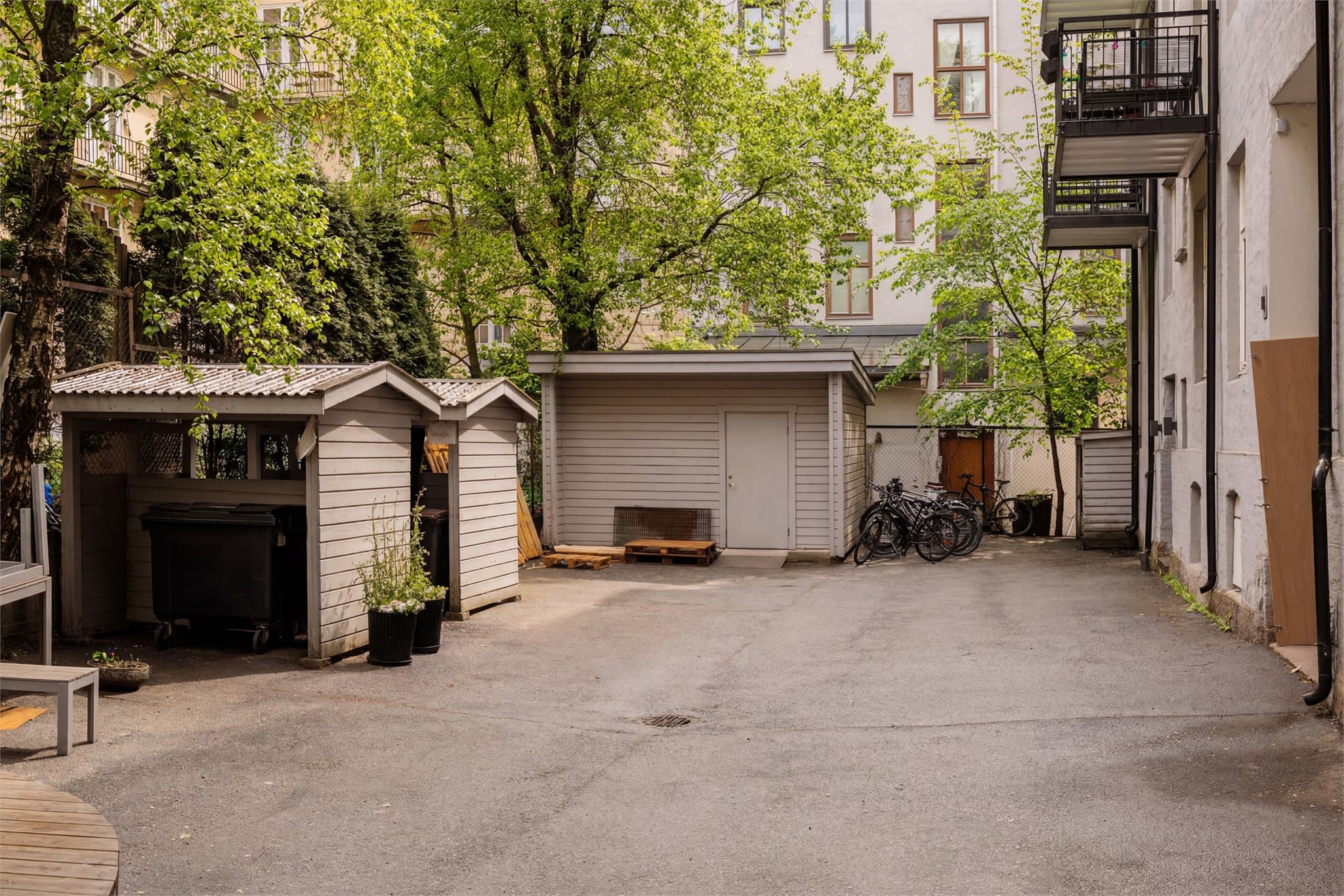 Borettslaget har en skjermet og hyggelig bakgård med sykkelparkering. Bildet er AI redigert.