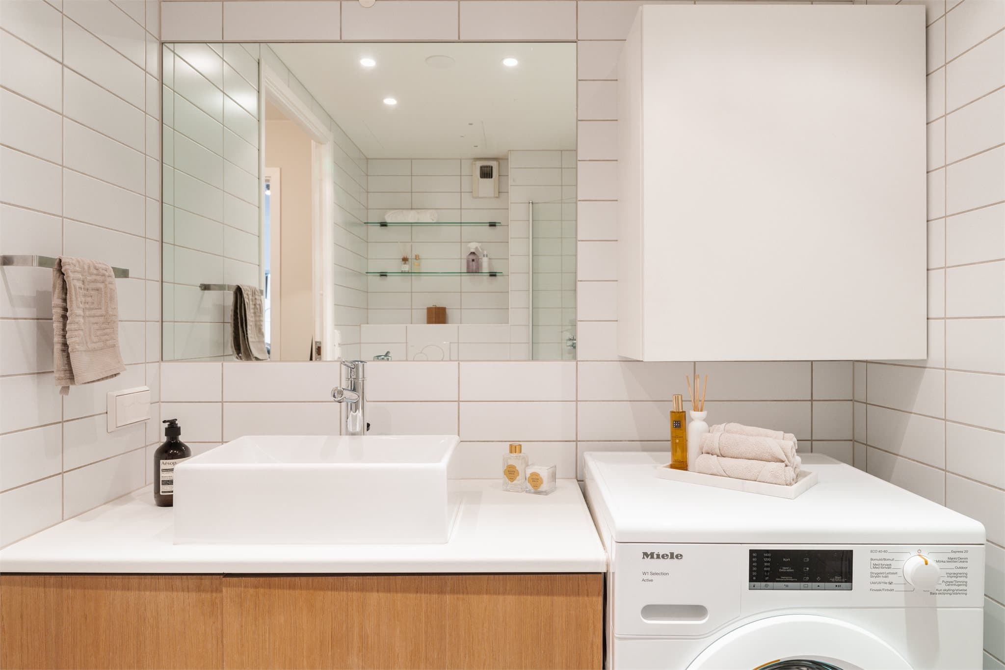 Stort speil, toppmontert servant og praktisk oppbevaringsskap som holder badet ryddig