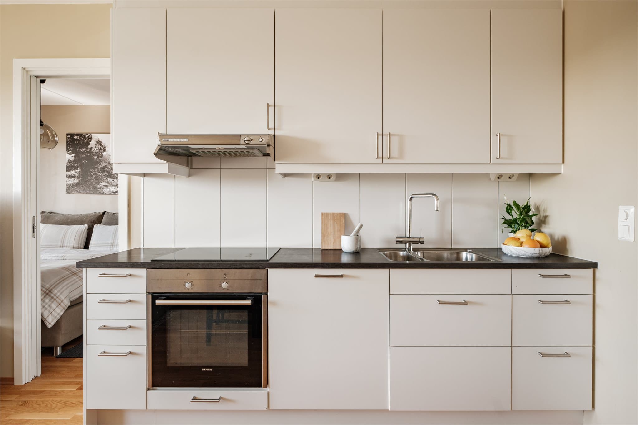 Kjøkkenet fremstår lyst og stilrent med gode arbeidsflater og godt med lagringsplass.