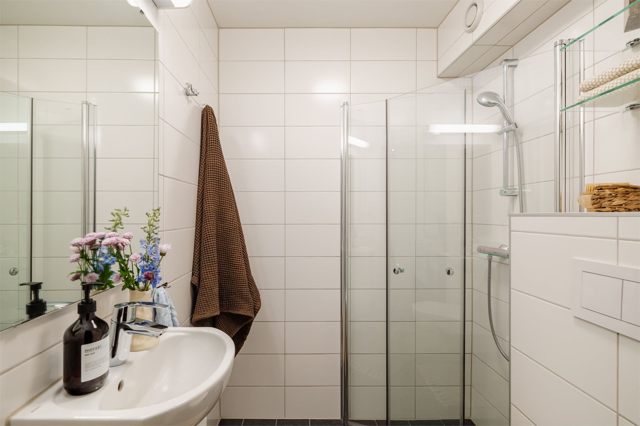Badet ble oppgradert i 2018 med hvite veggfliser, servant med underskap og dusjhjørne.
