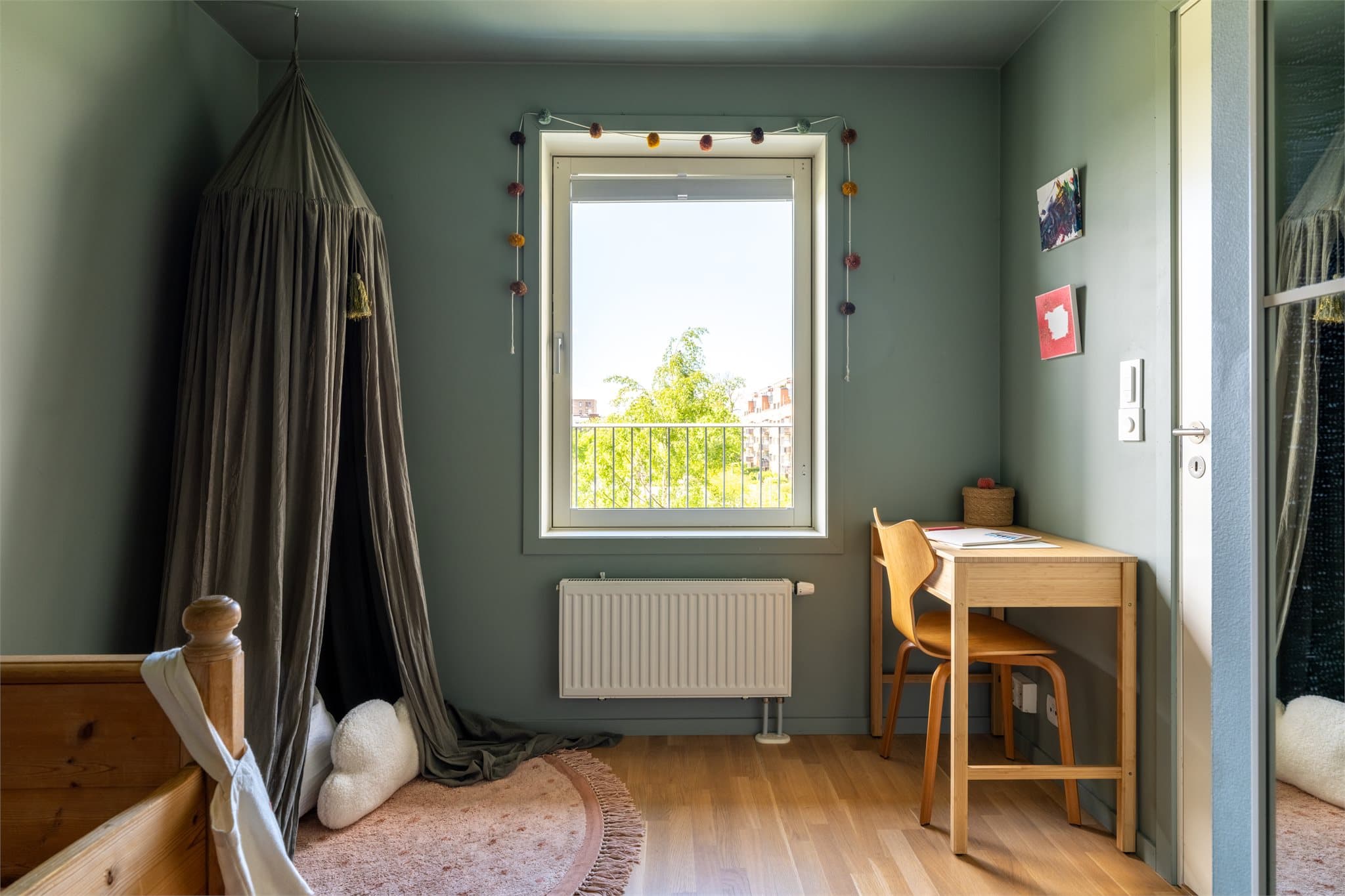 Rommet har et nydelig utsyn mot grønne omgivelser og er malt i en dyp grønnfarge som skaper en lun og rolig atmosfære.