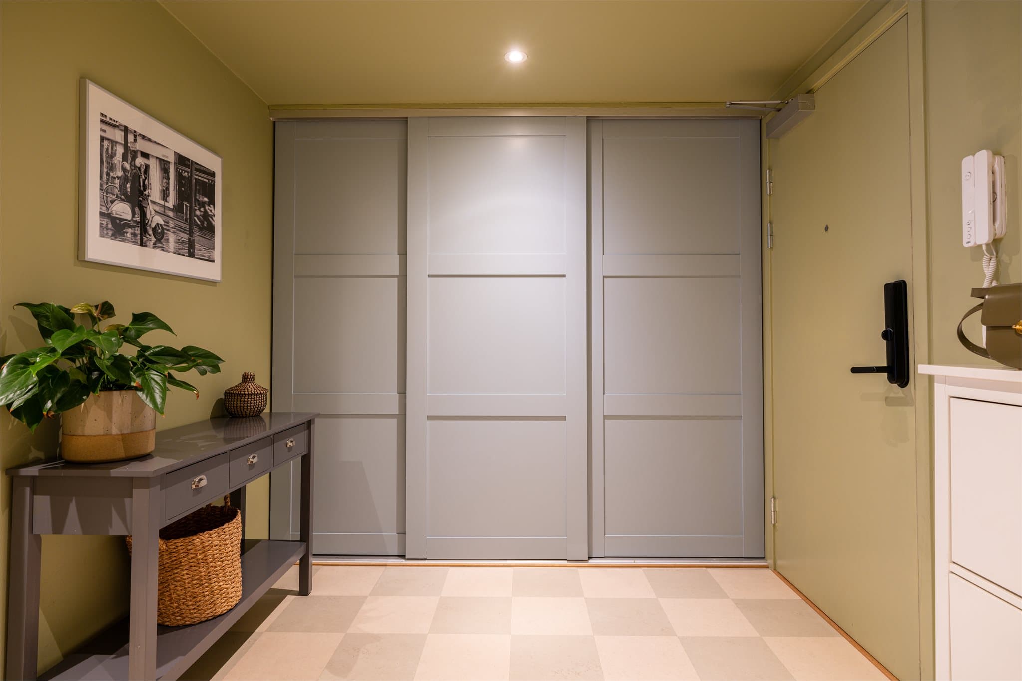 Entréen er utstyrt med en plassbygget skyvedørsgarderobe som gir rikelig med oppbevaringsplass til yttertøy og sko. I tillegg er boligen utstyrt med Yale Doorman, som gir en praktisk og trygg nøkkelfri adgangsløsning.