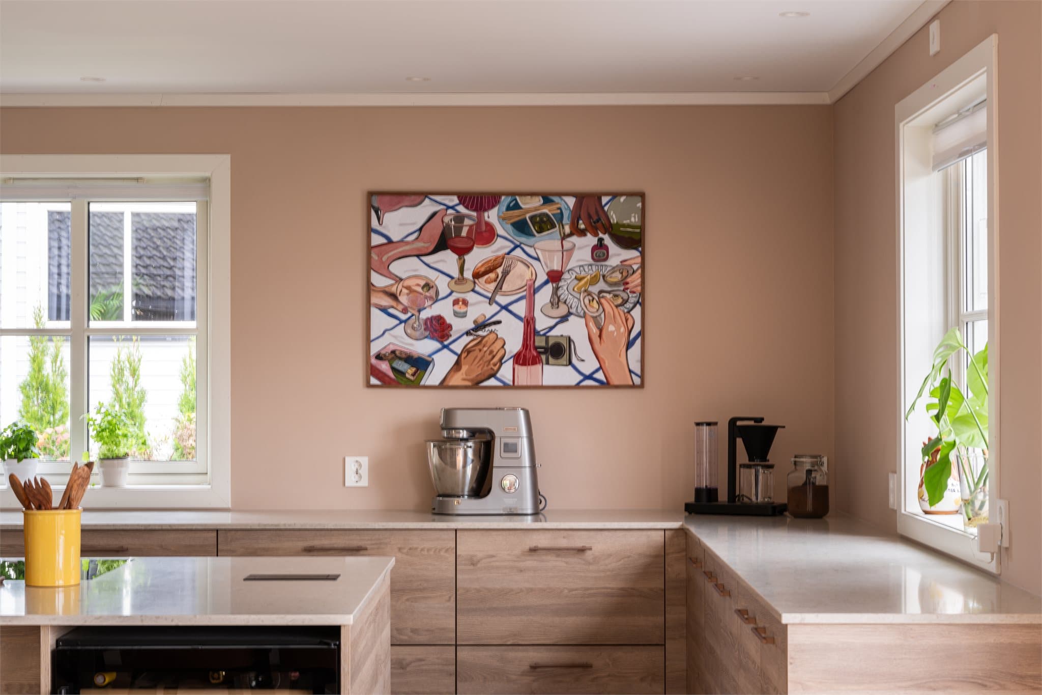 Benkeplaten i kompositt kombinerer eleganse og slitestyrke, mens kjøkkenøya gir ekstra arbeidsplass og naturlig samlingspunkt.