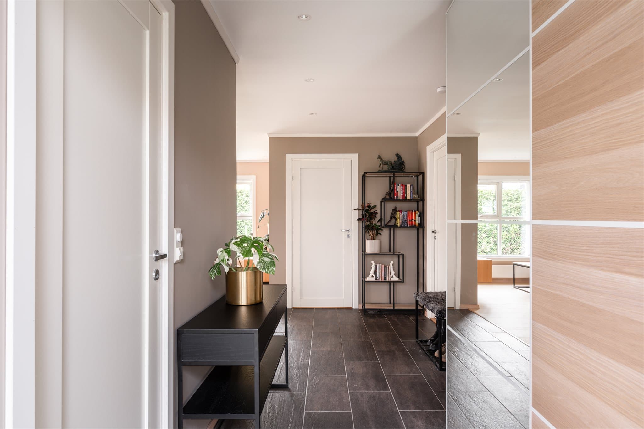 En stilren og innbydende entré ønsker dere velkommen inn. Rommet fremstår ryddig og luftig, med flislagt gulv som både er praktisk og pent.