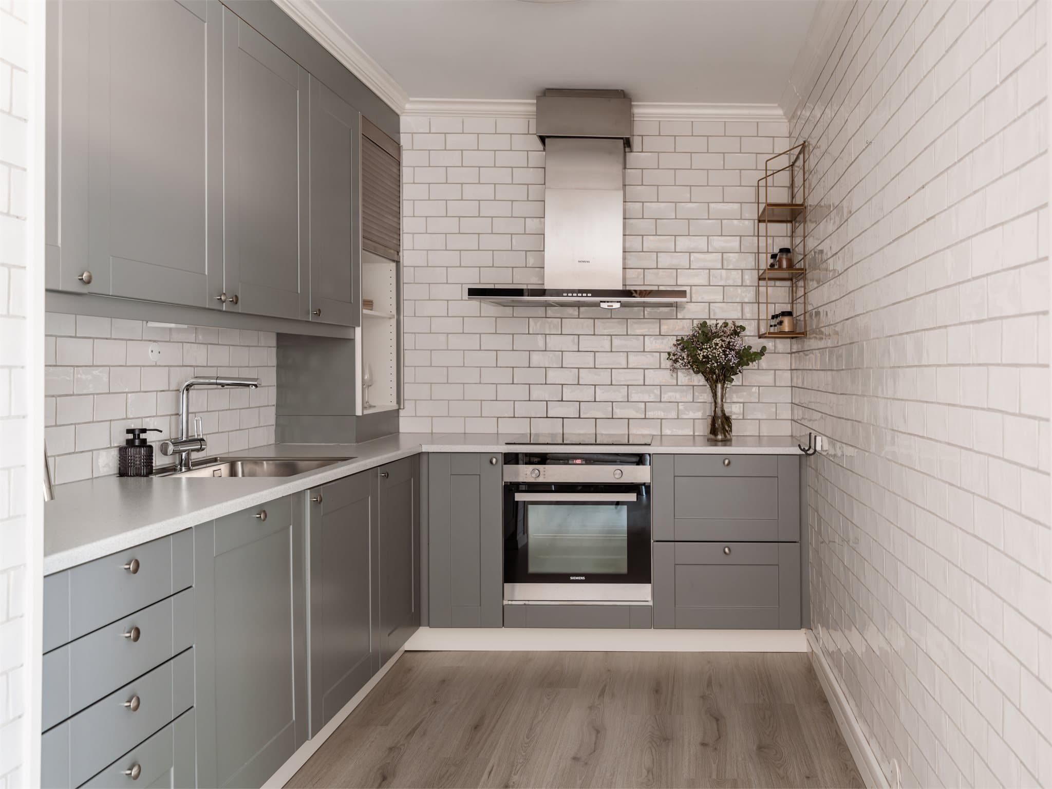 Kjøkkenet fra 2016 har en grå, glatt innredning fra Norema med integrerte hvitevarer.