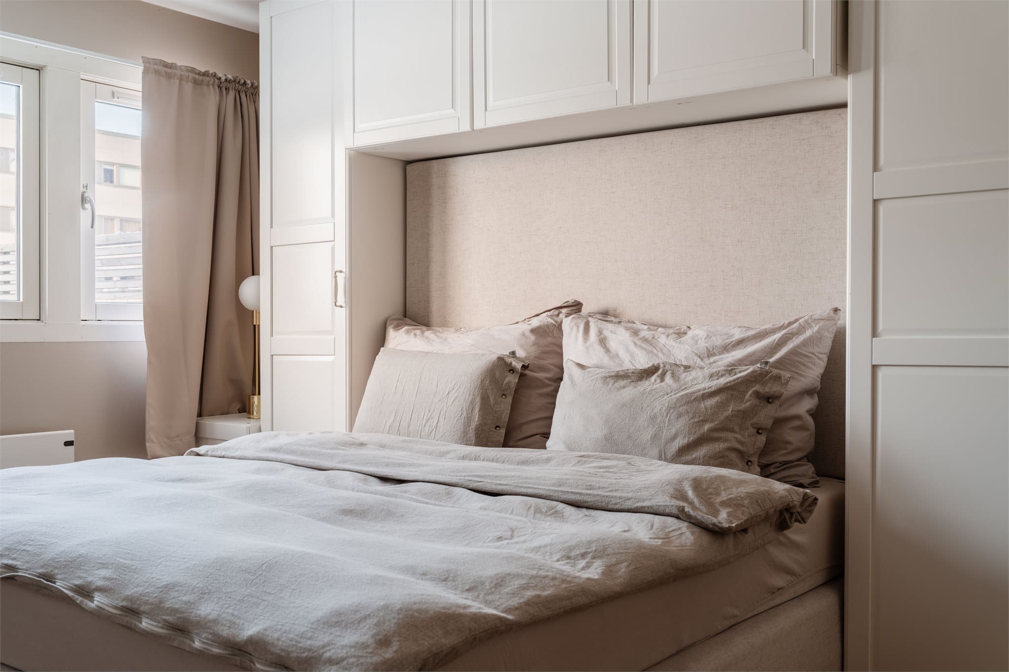 Den smarte garderobeløsningen gir rikelig med oppbevaringsplass og rammer inn sengen.