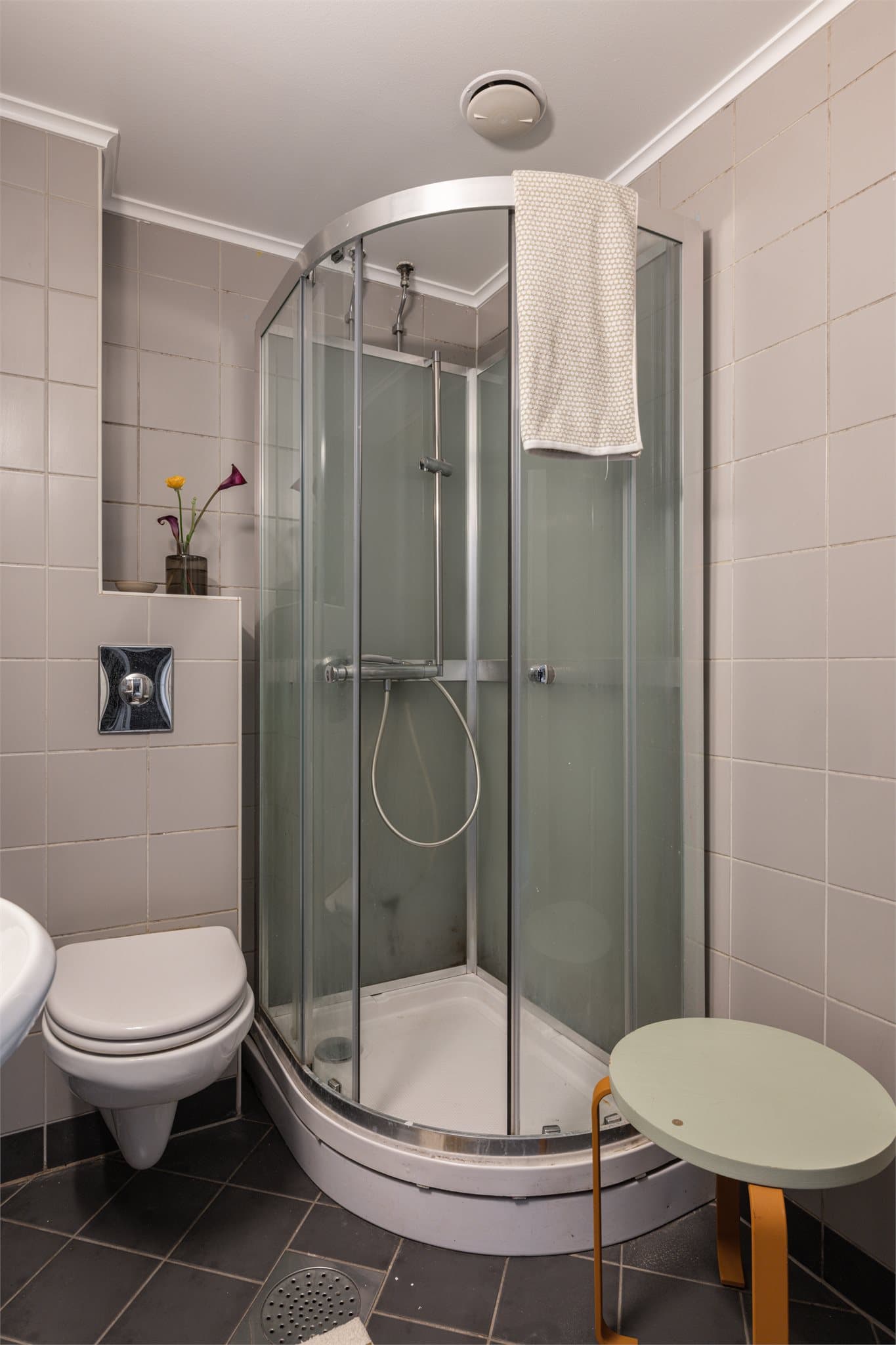 Badet har dusjkabinett og opplegg for vaskemaskin på siden.