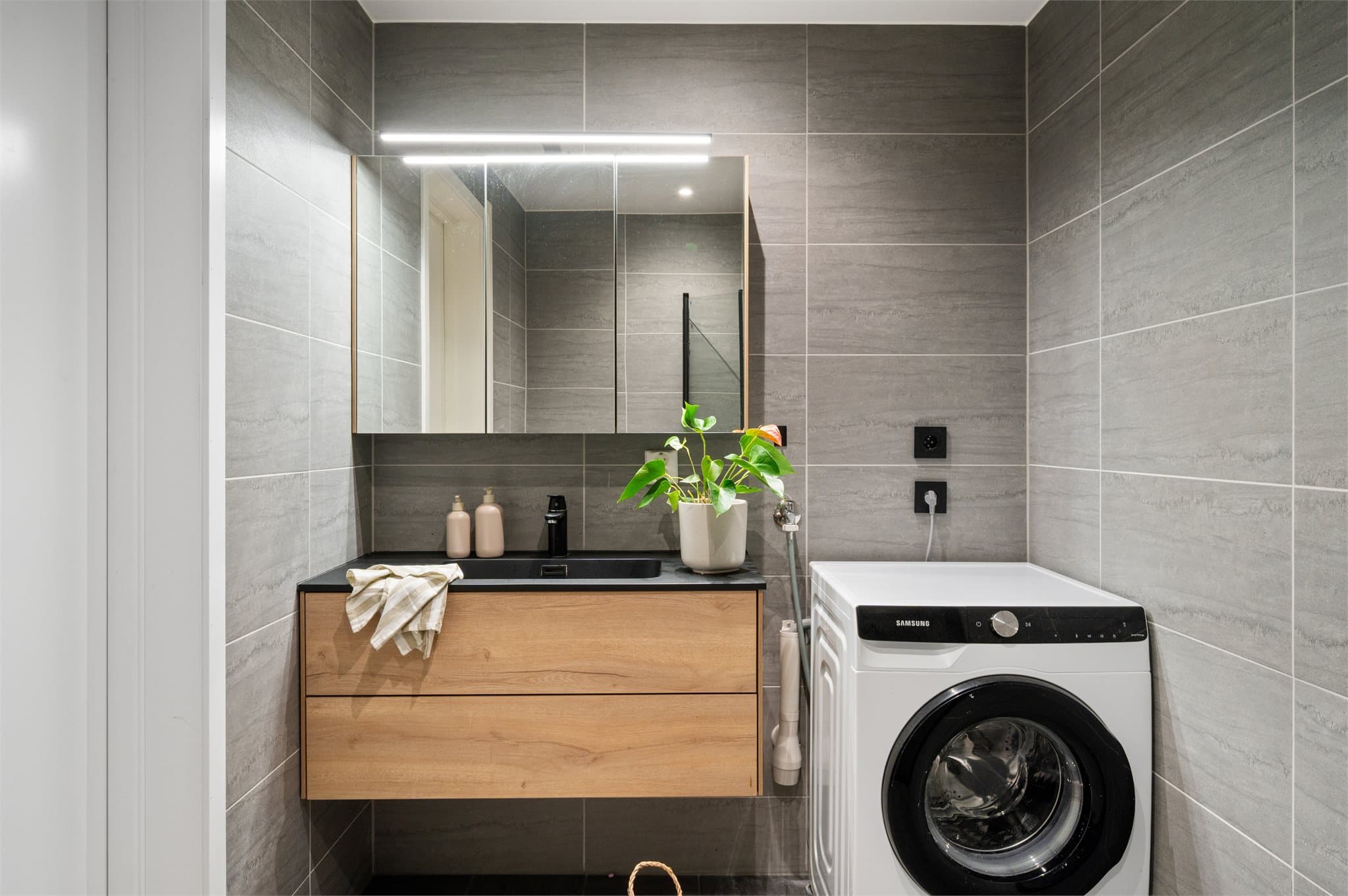 - Innredet med heldekkende servant, speilskap med belysning, vegghengt toalett, dusjhjørne og opplegg for vaskemaskin -