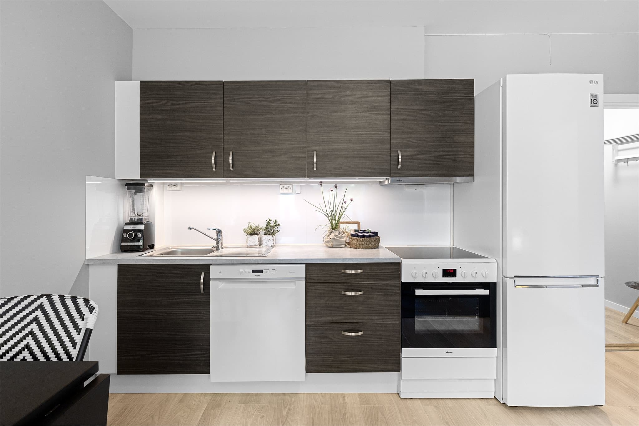 Kjøkkenet har innredning med glatte fronter, benkeplaten er av laminat, og det er vannstoppsystem og komfyrvakt. Kjøkkenventilator med kullfilter.