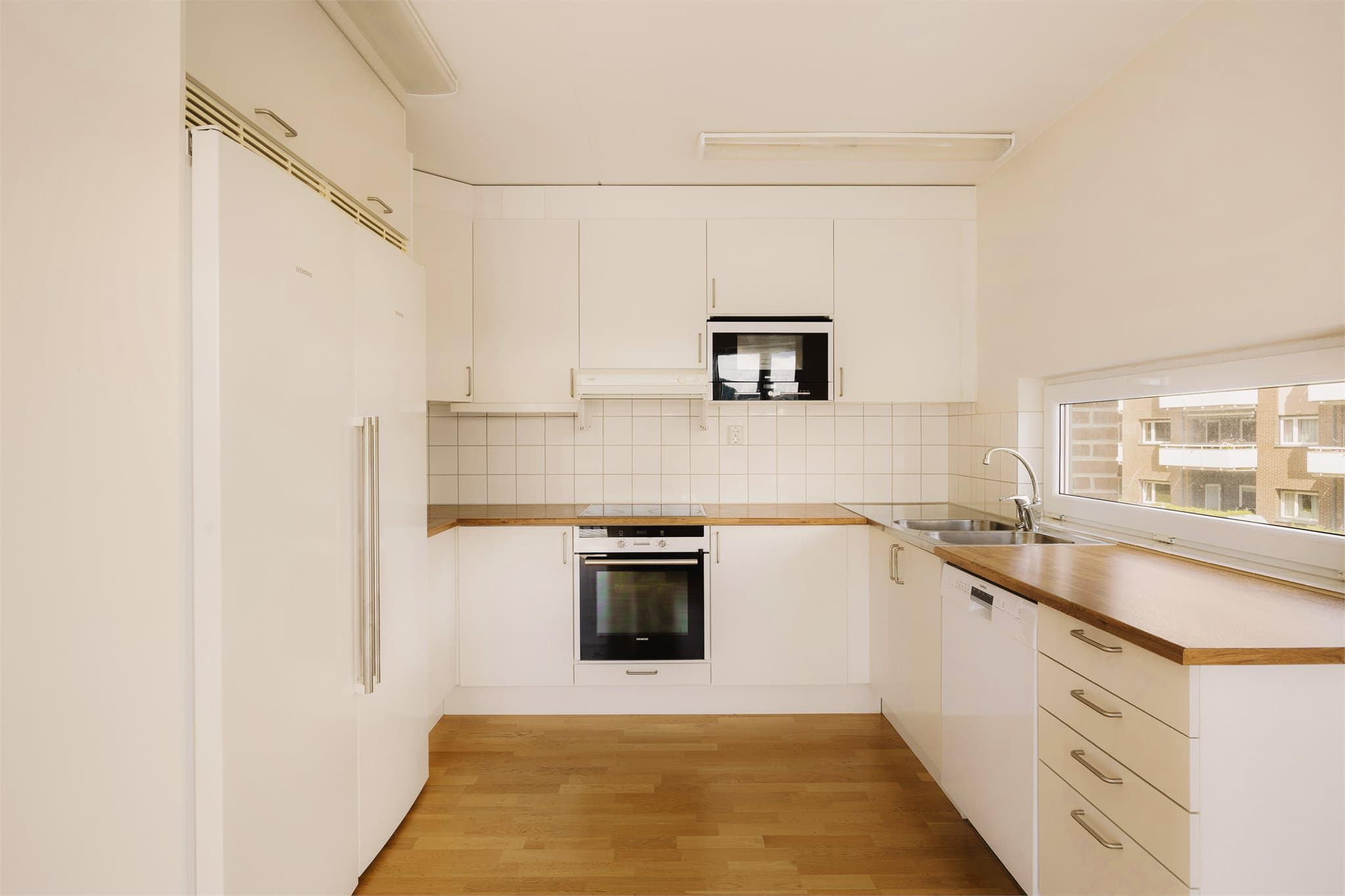 Kjøkken Ifølge eier fra byggeår. Lys og tidløs kjøkkeninnredning med glatte fronter og benkeplate i laminat. Det er integrerte hvitevarer som platetopp, stekeovn, oppvaskmaskin, kjøleskap og fryser.