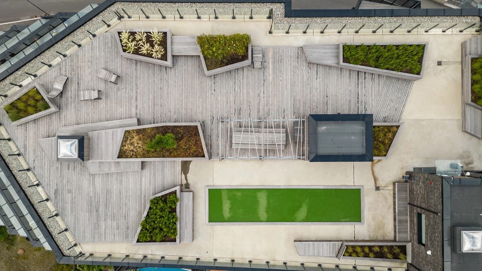 Takterrassen er pent opparbeidet med tredekke, beplantning og flere soner for opphold.