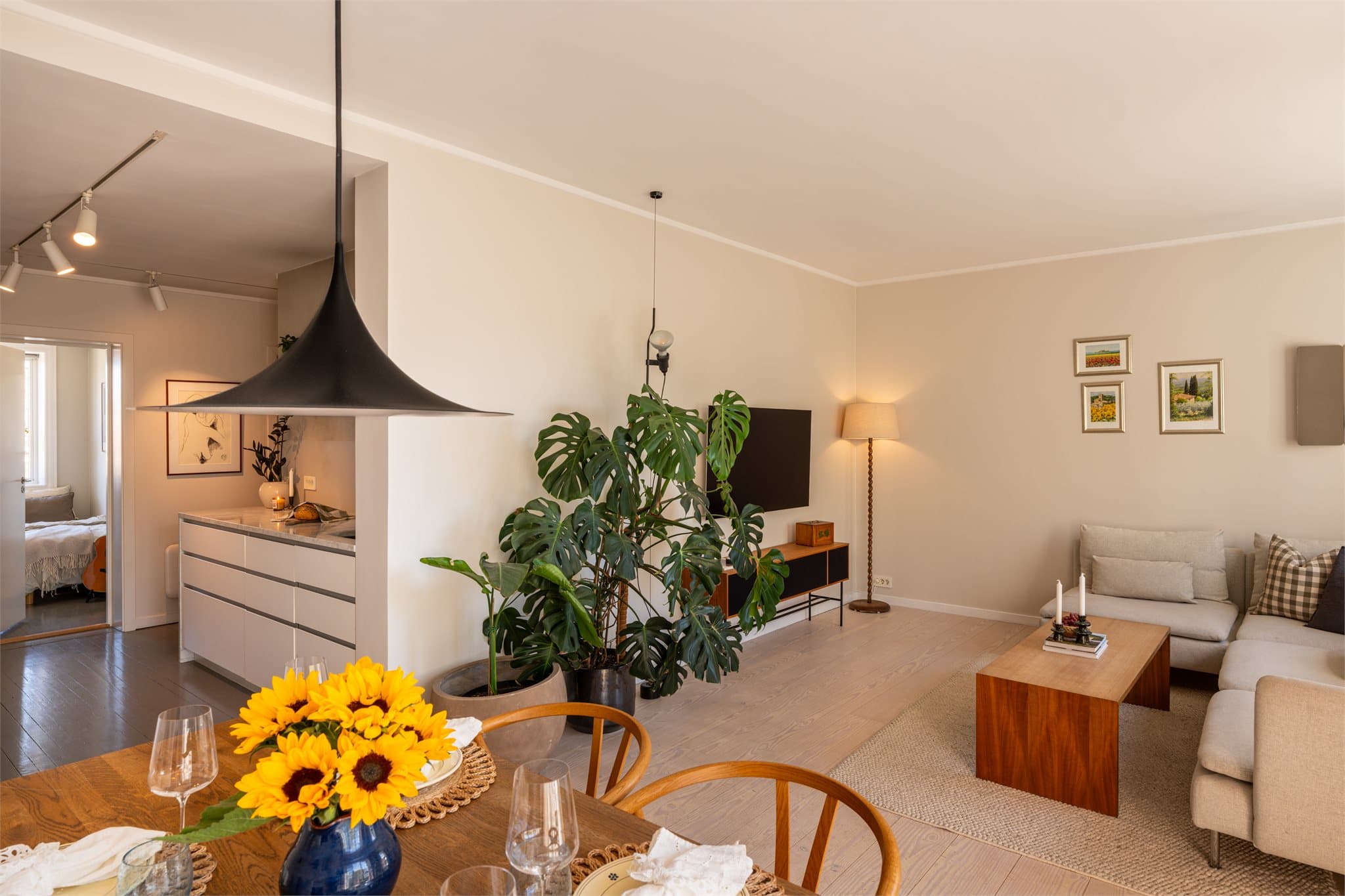 Den åpne løsningen mellom kjøkken og stue skaper en sosial og innbydende atmosfære.