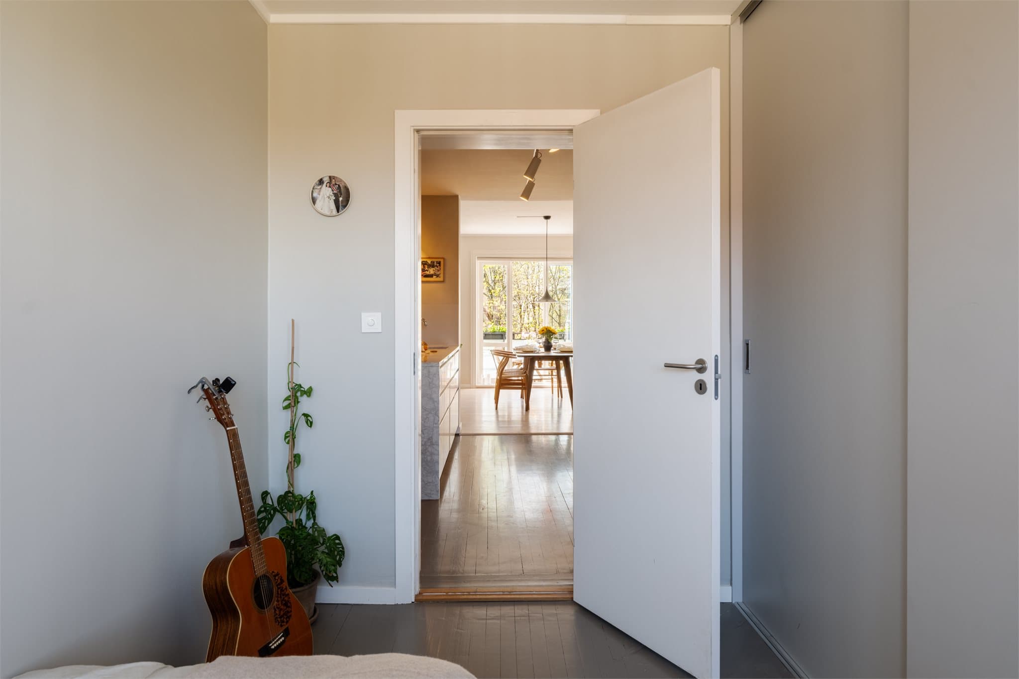 Fra soverommet ser man gjennom leiligheten mot stuen og dagslyset fra balkongen.