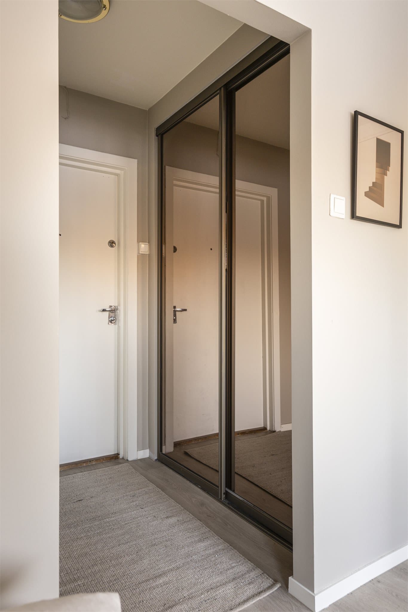 Entréen er utstyrt med en skyvedørsgarderobe med speilfronter som bidrar til en luftig romfølelse.