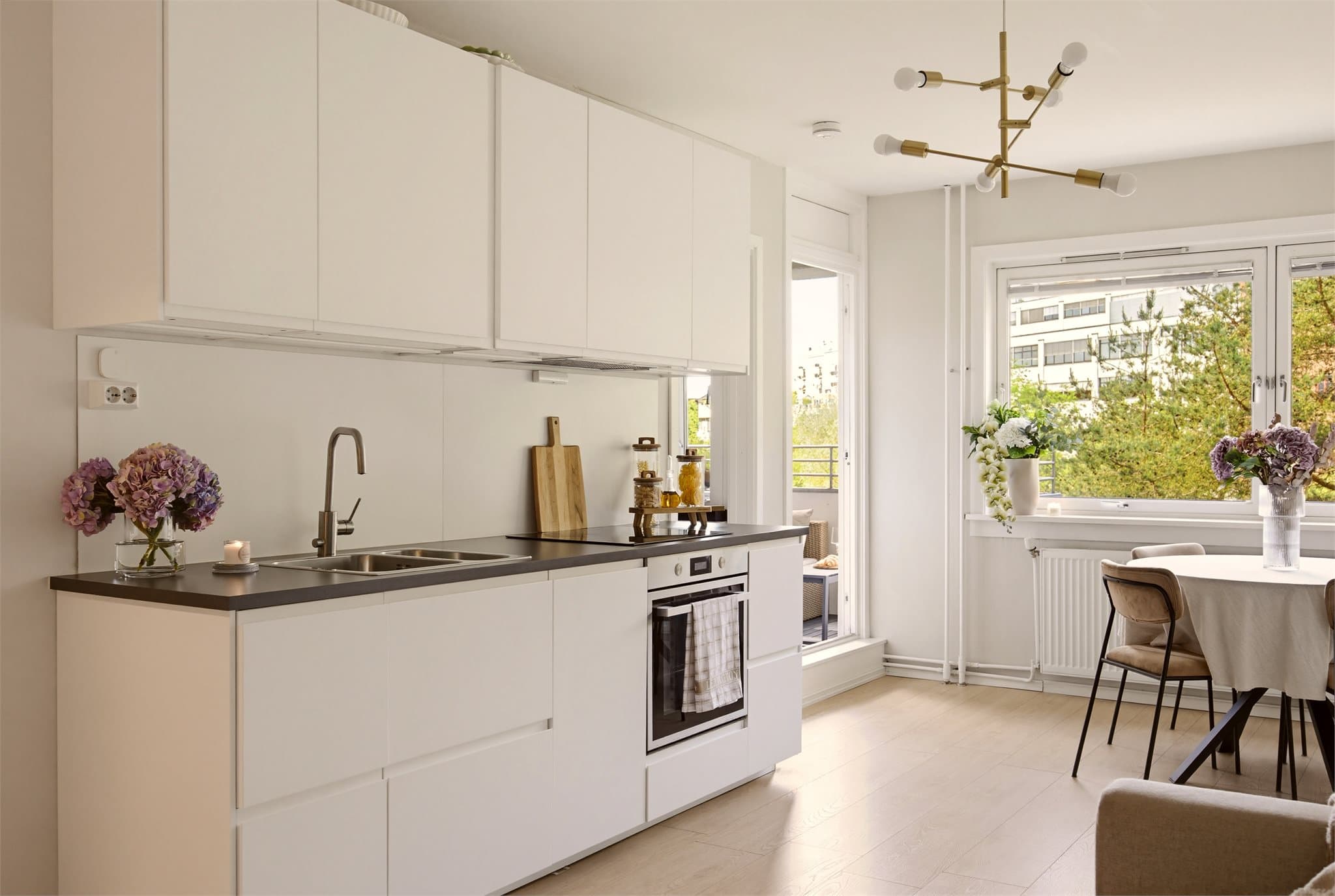 Kjøkkenet er plassert langs innerveggen og vender ut mot stuen. Den åpne utformingen gjør at matlagingen kobles fritt sammen med oppholdssonen, noe som gir en effektiv utnyttelse av arealet.