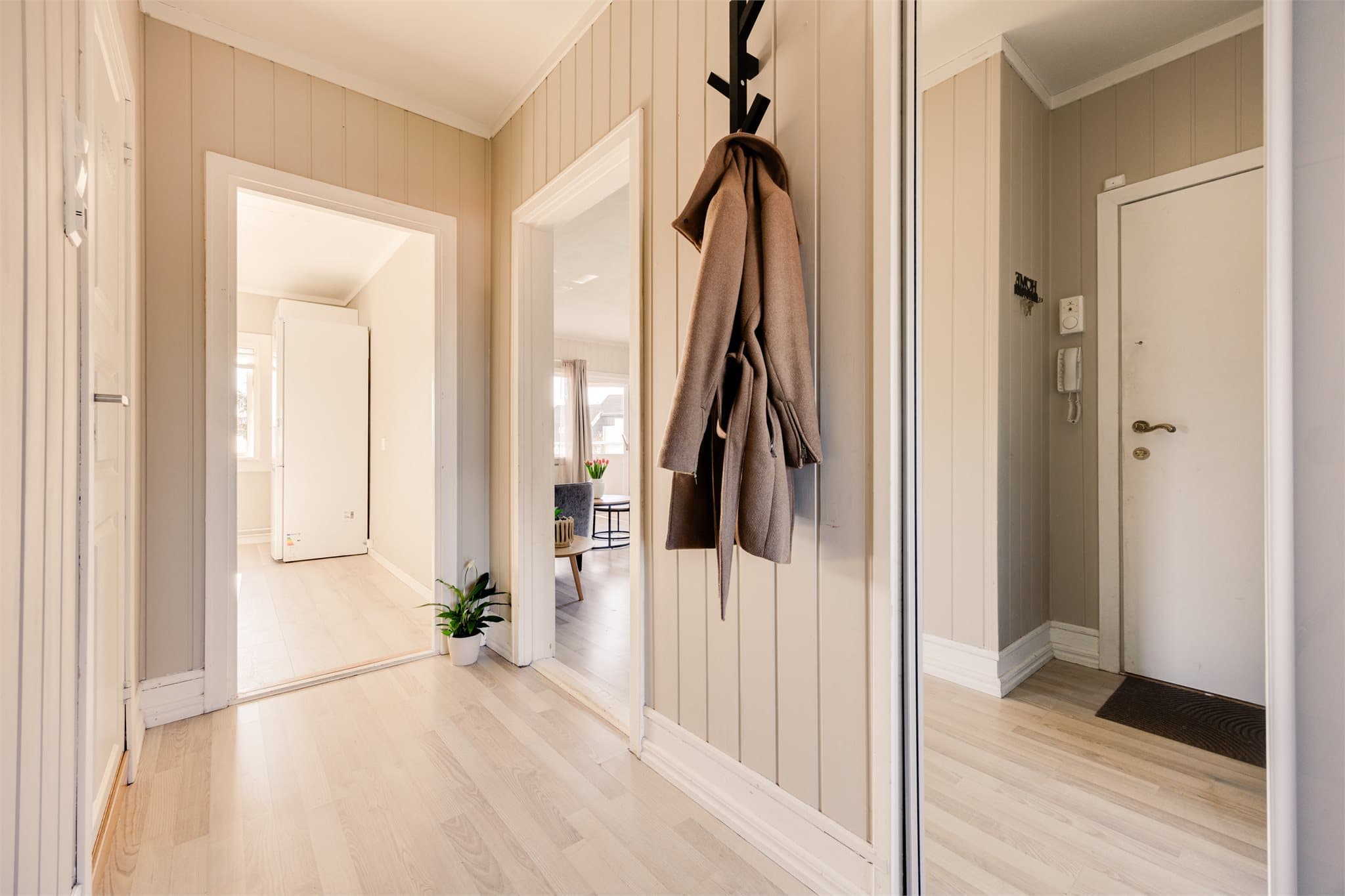 Entréen gir et hyggelig førsteinntrykk med beige vegger og fliser på gulv.