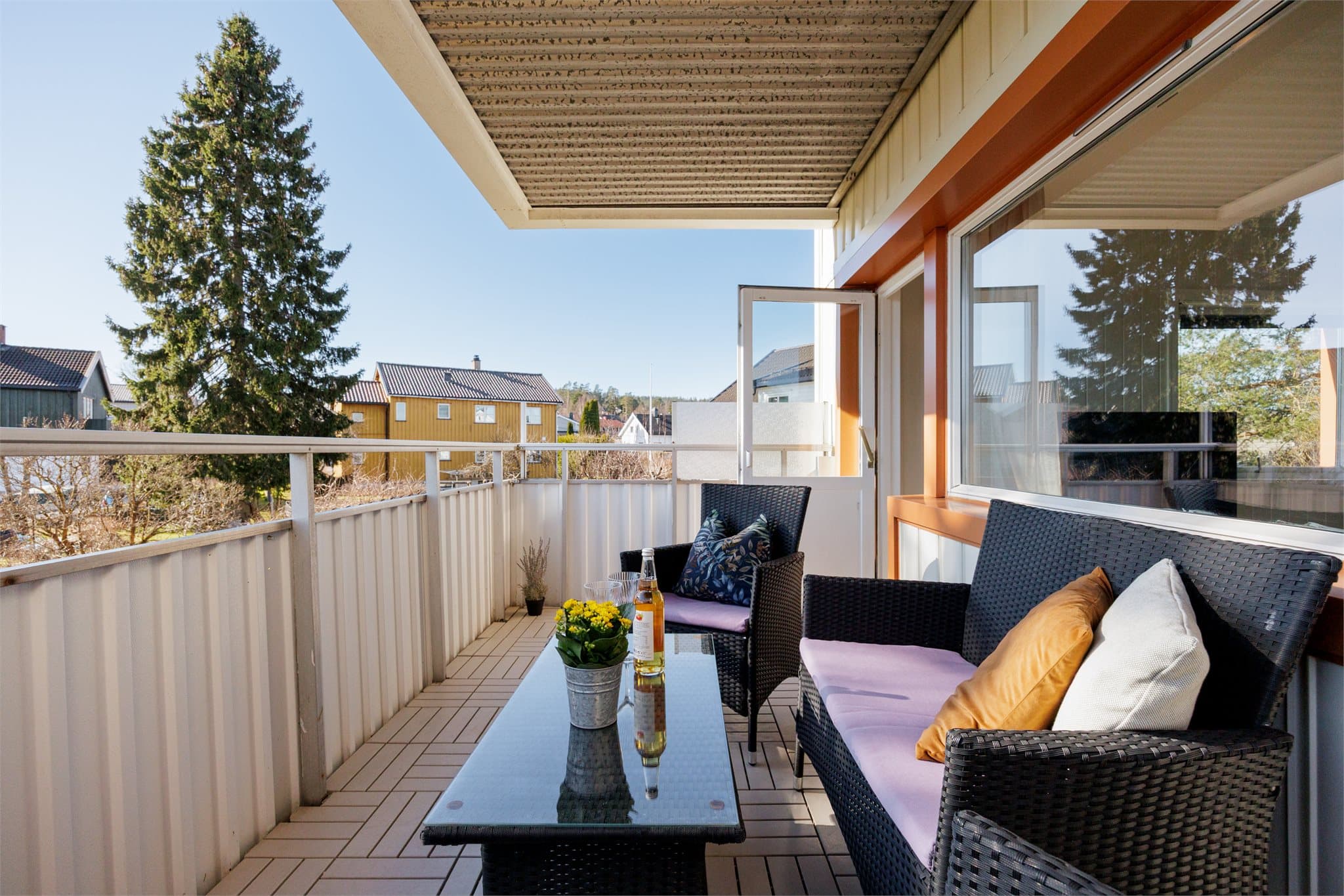 Herfra har du utsyn mot koselig grønt areal hvor barna kan leke i trygge omgivelser - mens de voksene koser seg i solen.