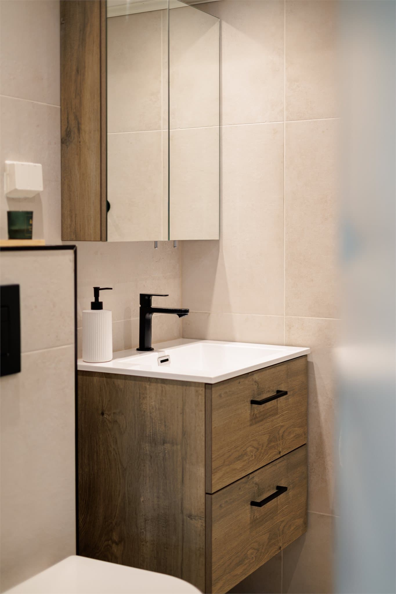 Innredningen består av benkeskap med glatte fronter og speilskap.