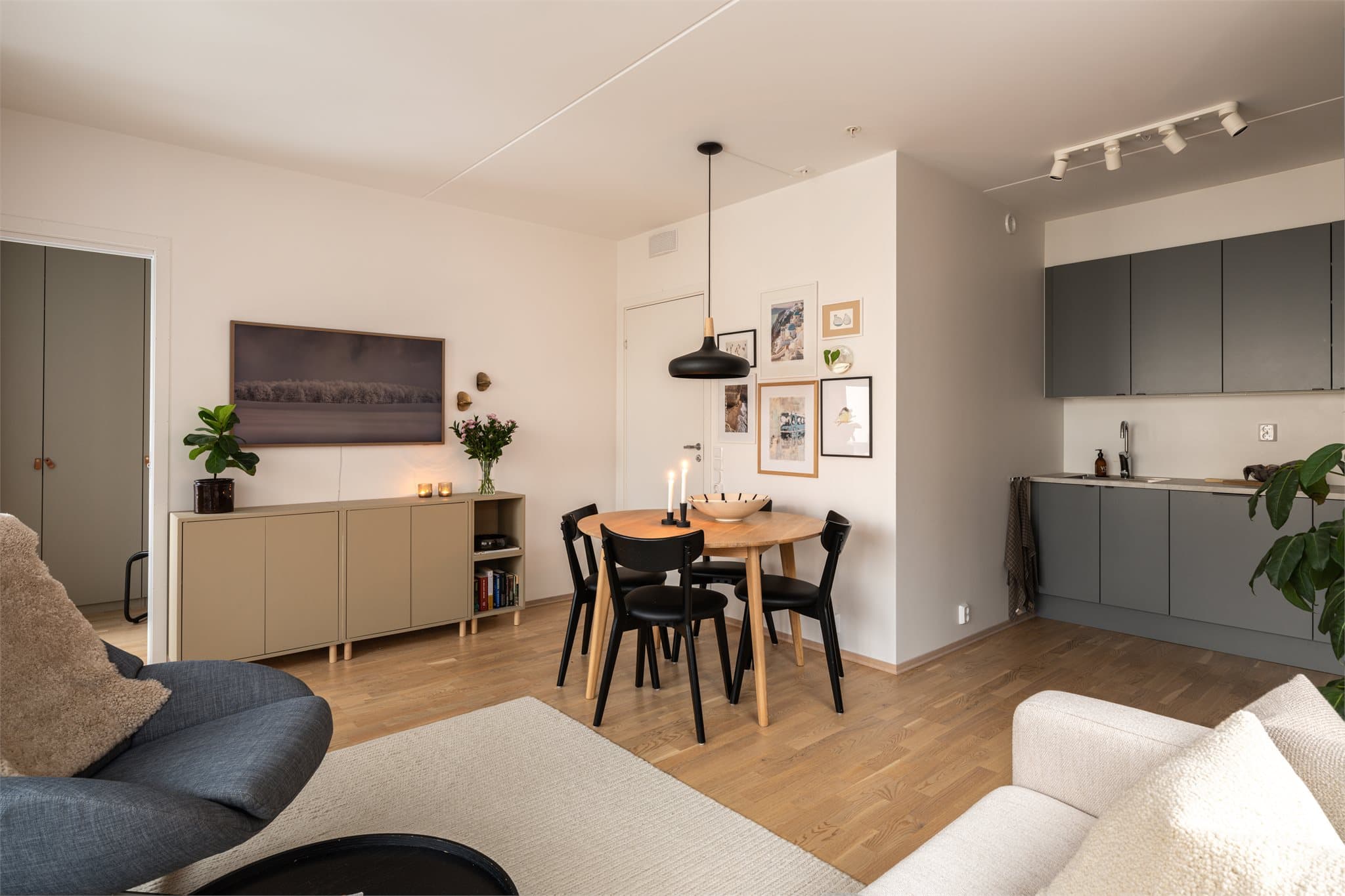 Den åpne løsningen mellom stue og kjøkken skaper en sosial og luftig atmosfære.