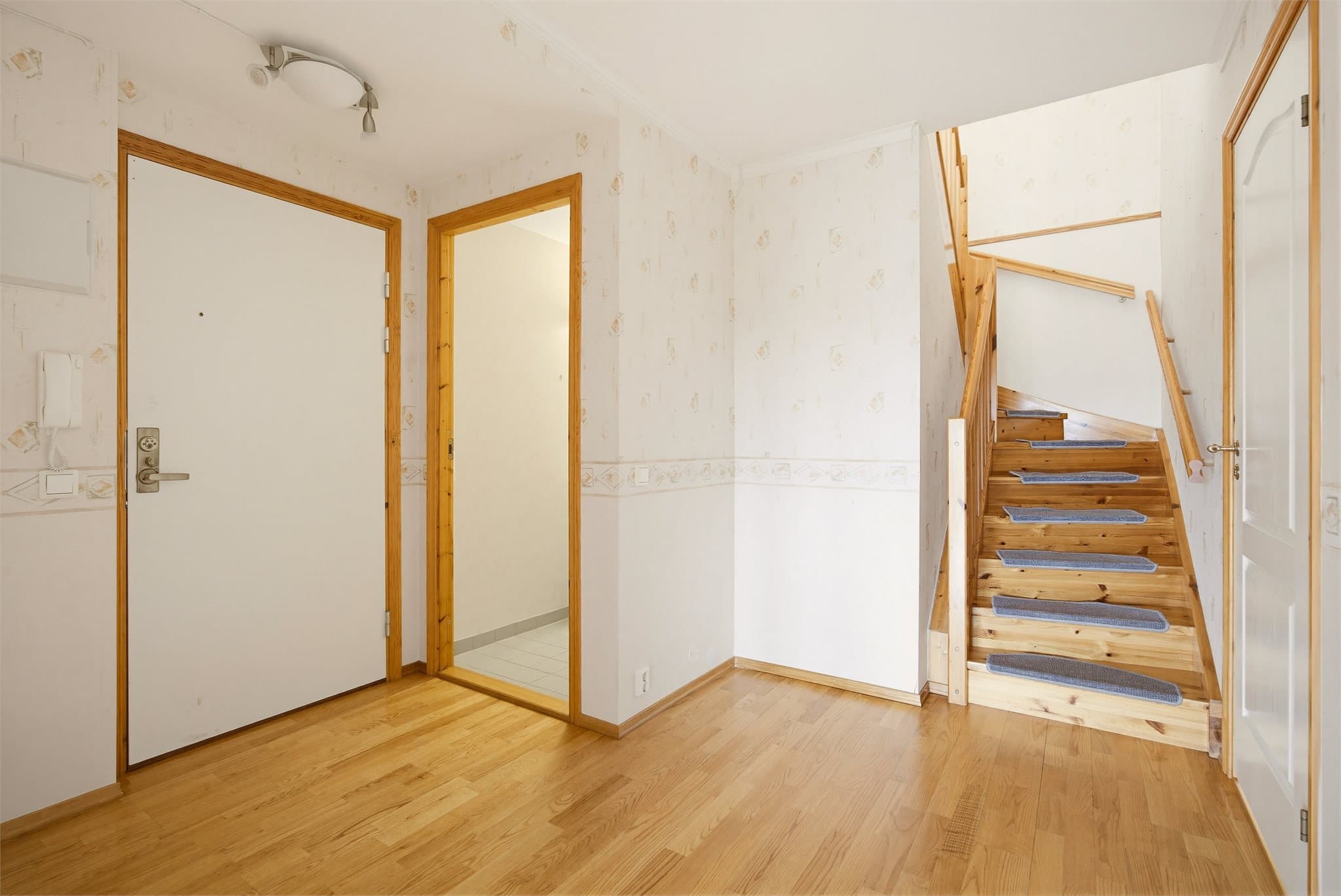 Innbydende inngangsparti med trappeforbindelse til boligens toppetasje.