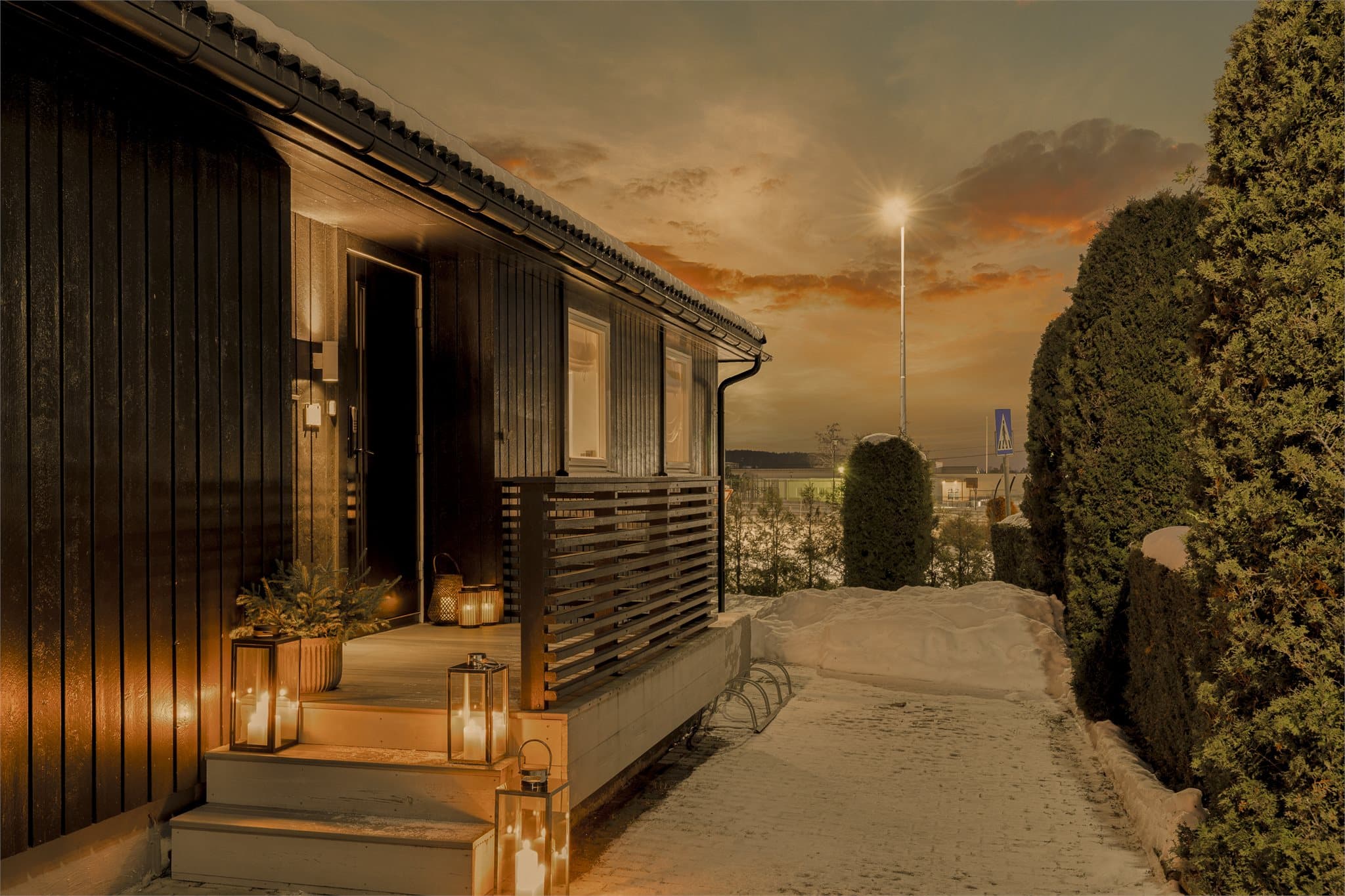 På fremsiden av boligen har man steinlagt gårdsplass og et opphøyet inngangsparti.