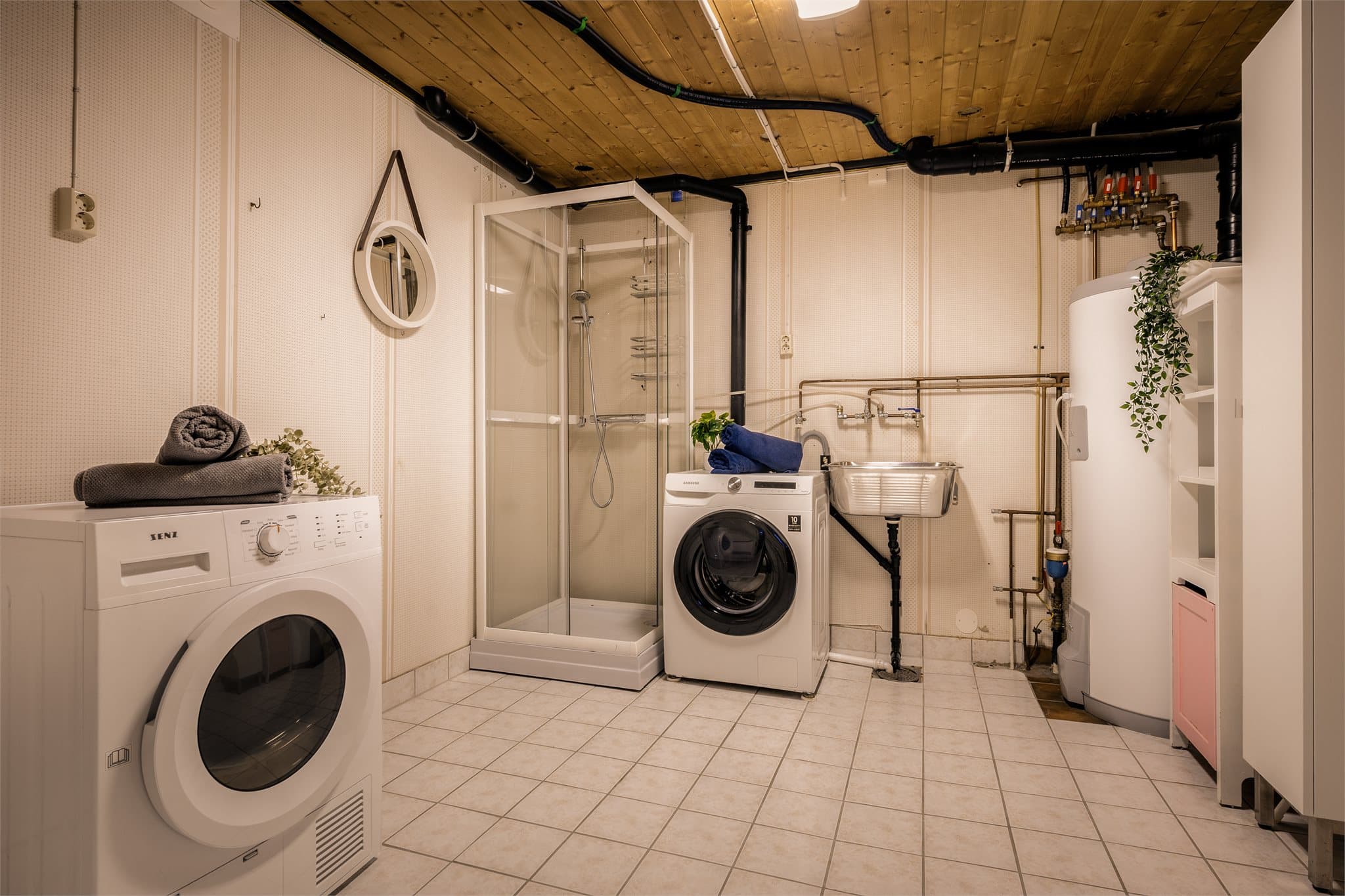 Vaskerom innredet med dusjkabinett, utslagsvask og høyskap. Nyere varmtvannsbereder.