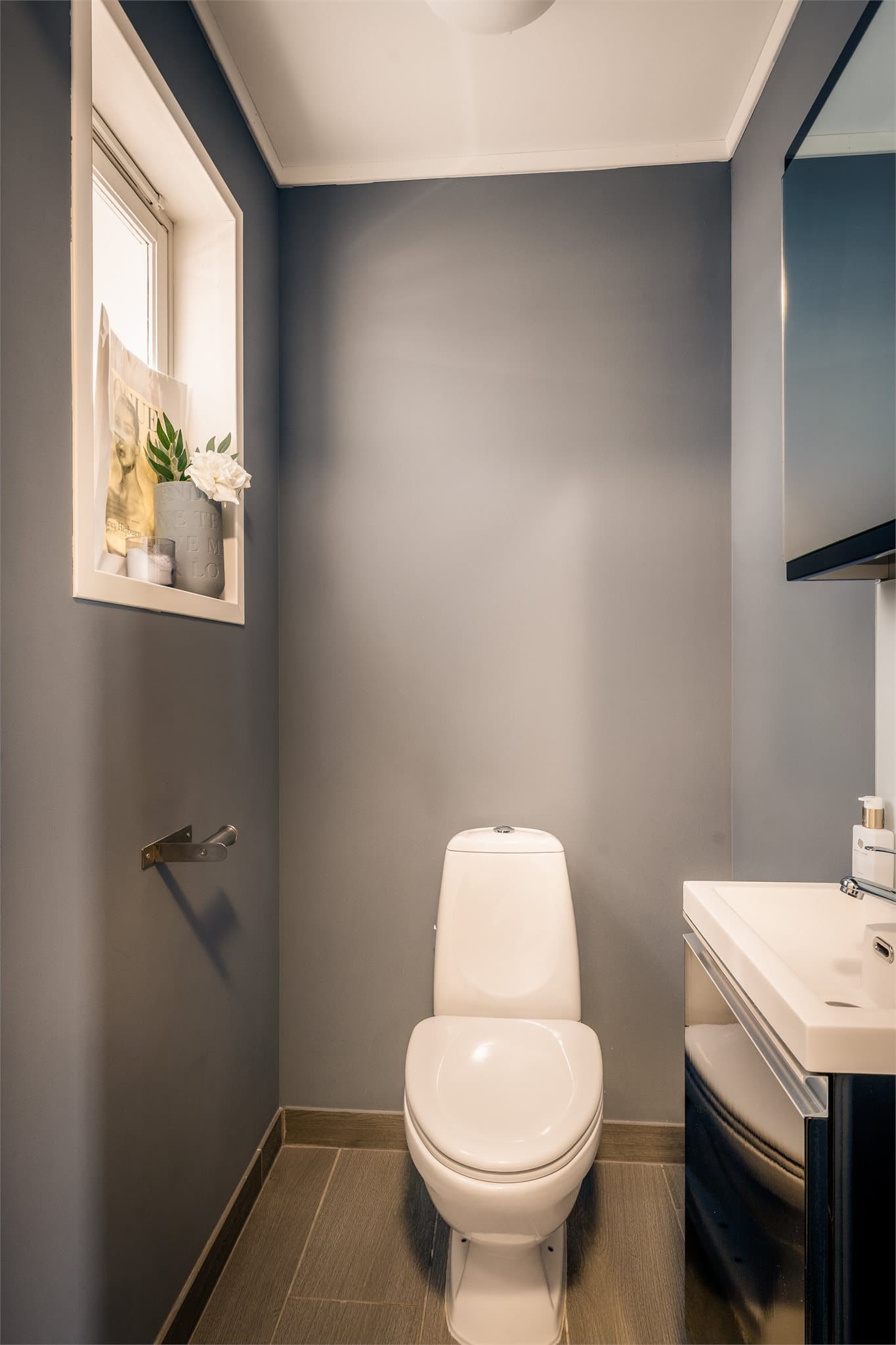 Fra entreen har man adkomst til toalettrom, innredet med klosett og servantmøbel.