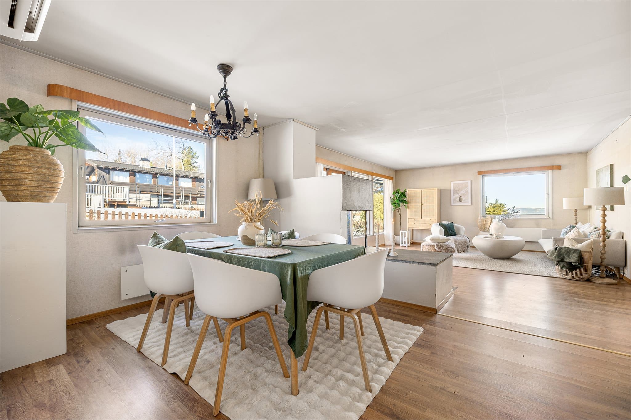 Her får du en dedikert spisestuesone med god plass. Rommet glir naturlig over i stuen, noe som skaper en sosial og åpen løsning med peisen som et naturlig midtpunkt.