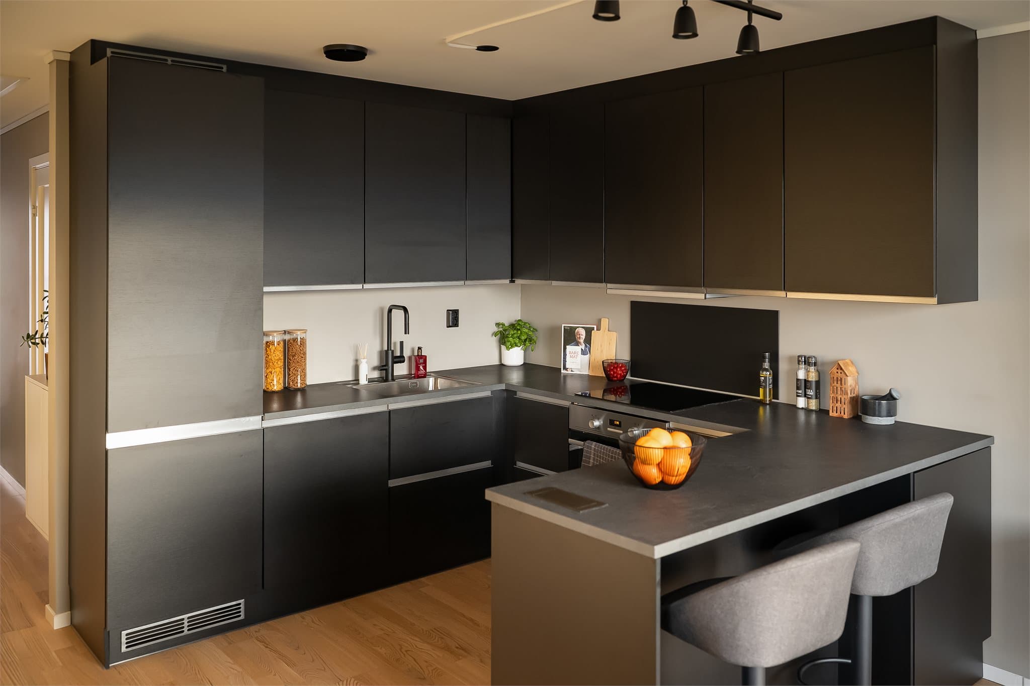 Et komplett kjøkken med alt du trenger av hvitevarer som: Oppvaskmaskin, kjøleskap, stekeovn og platetopp.