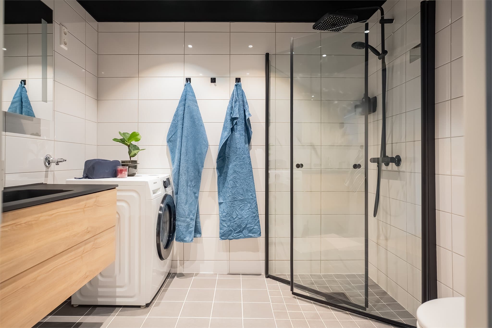 Lekkert, flislagt baderom med varme i gulvet og opplegg for vaskemaskin.