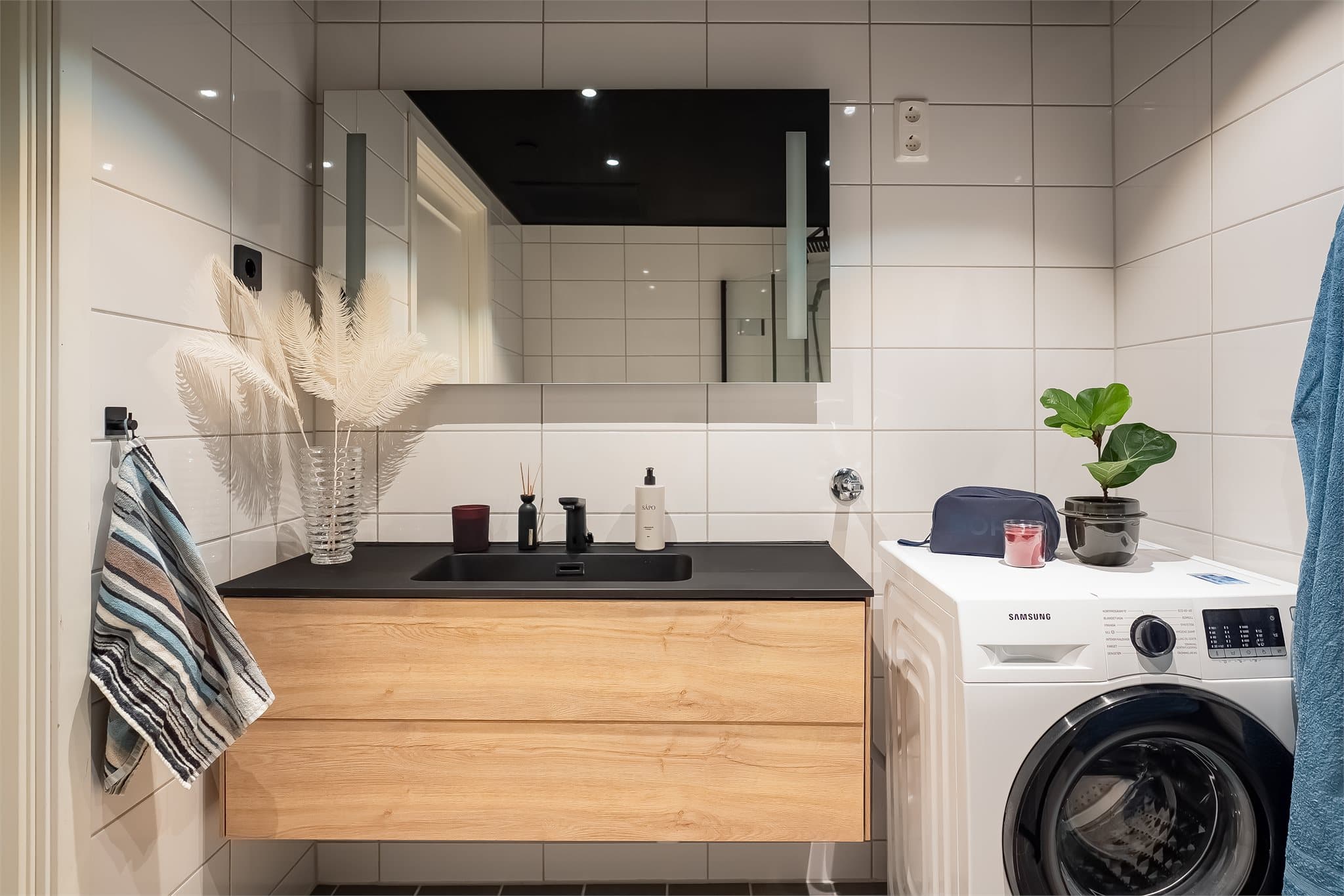 Sorte detaljer gir rommet et eksklusivt og moderne uttrykk. Den store baderomsinnredningen sørger for godt med oppbevaringsplass.