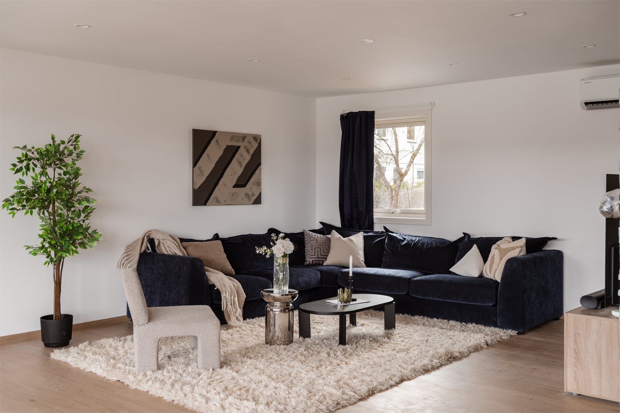 Stuen har nylig malte plater på veggene og plass til en romslig sofagruppe.