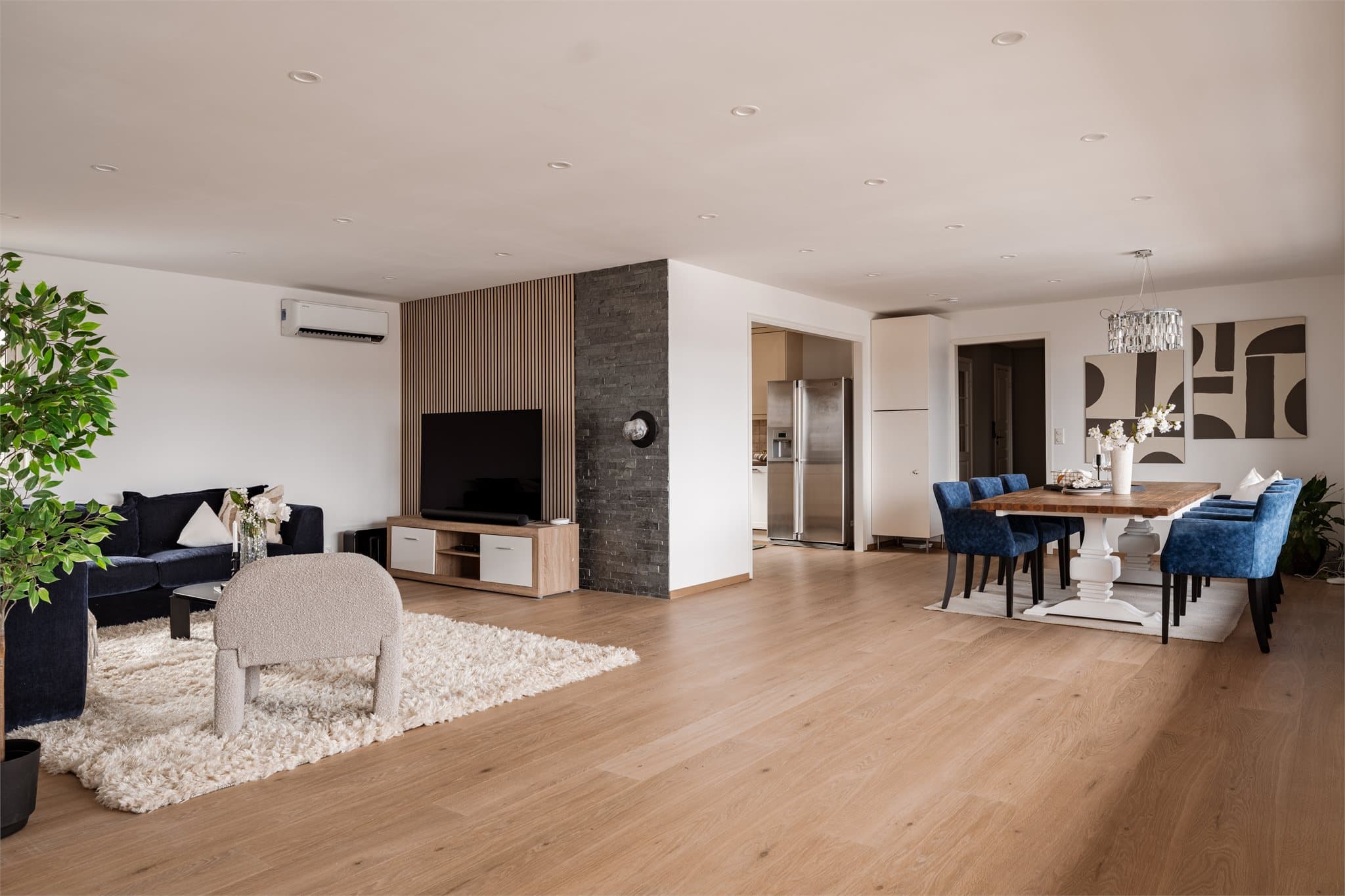 Den åpne stue- og spisestueløsningen gir en luftig romfølelse og fleksible møbleringssoner.